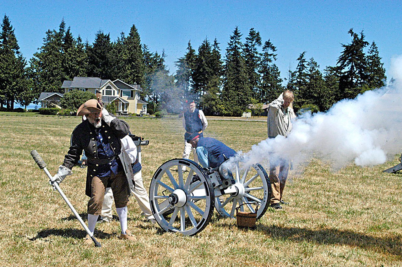 Mac McCurdy, left, of Phoenix; Chris Levi Evans, right, of El Centro, Calif.; and Bob Hays of El Centro fire a Grasshopper cannon in 2015 during the inaugural colonial festival at the George Washington Inn. They are a re-creation of the Royal Irish Artillery. (Chris McDaniel/Peninsula Daily News)