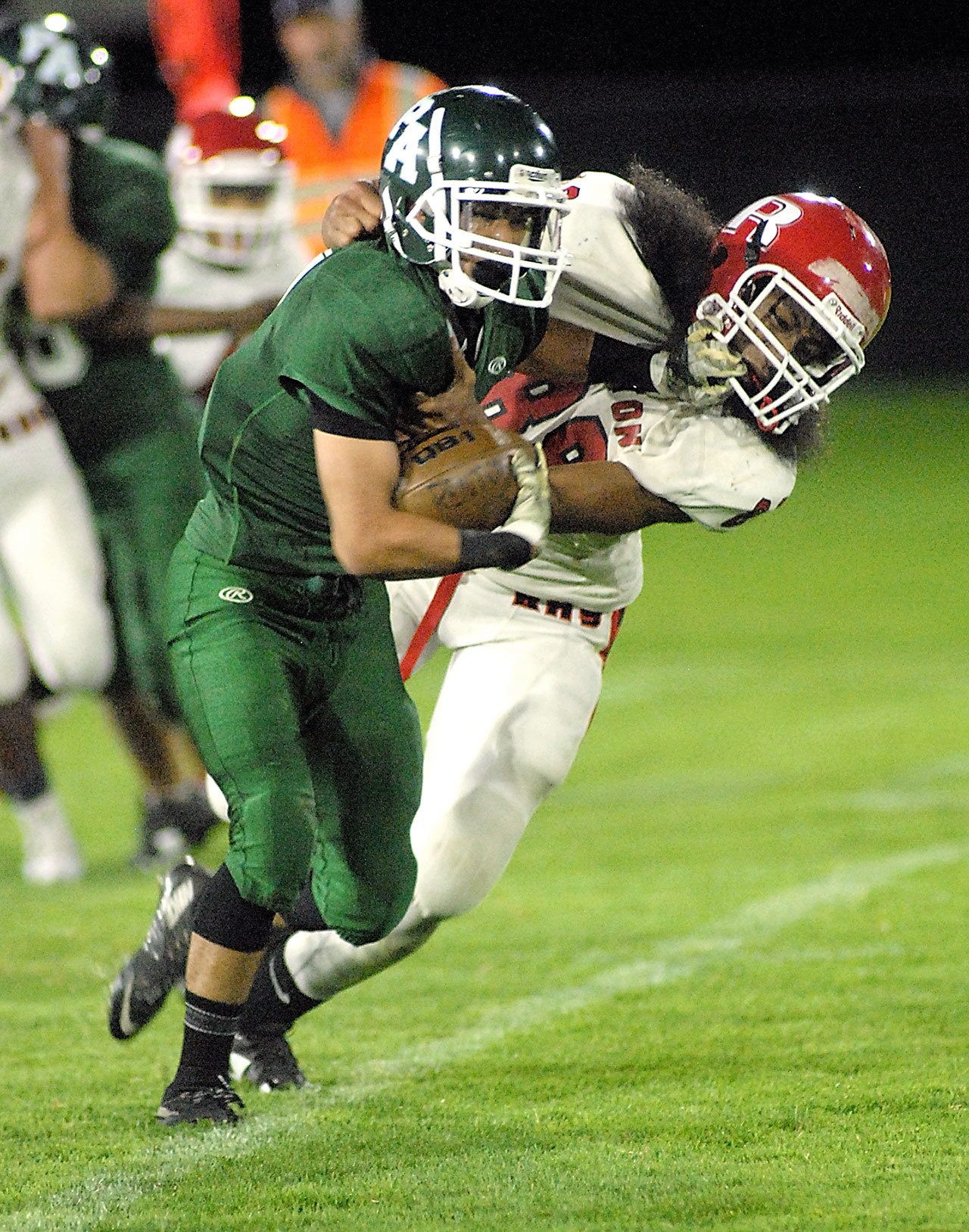 Keith Thorpe/Peninsula Daily News Port Angeles’ Rudy Valdez, left, fends off the defense of Renton’s Nefetalai Finau in the second quarter on Friday night at Port Angeles Civic Field.