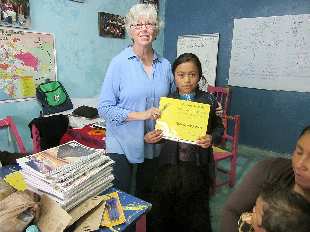 Judith Pasco, Mujeres de Maiz Opportunity Fund of Clallam County board chair, presents Rosa, a 5th grader, with a scholarship during a visit to Chiapas, Mexico in August. (Linda Finch) Judith Pasco, Mujeres de Maiz Opportunity Fund of Clallam County board chair, presents Rosa, a fifth-grader, with a scholarship during a visit to Chiapas, Mexico, in August. (Linda Finch)