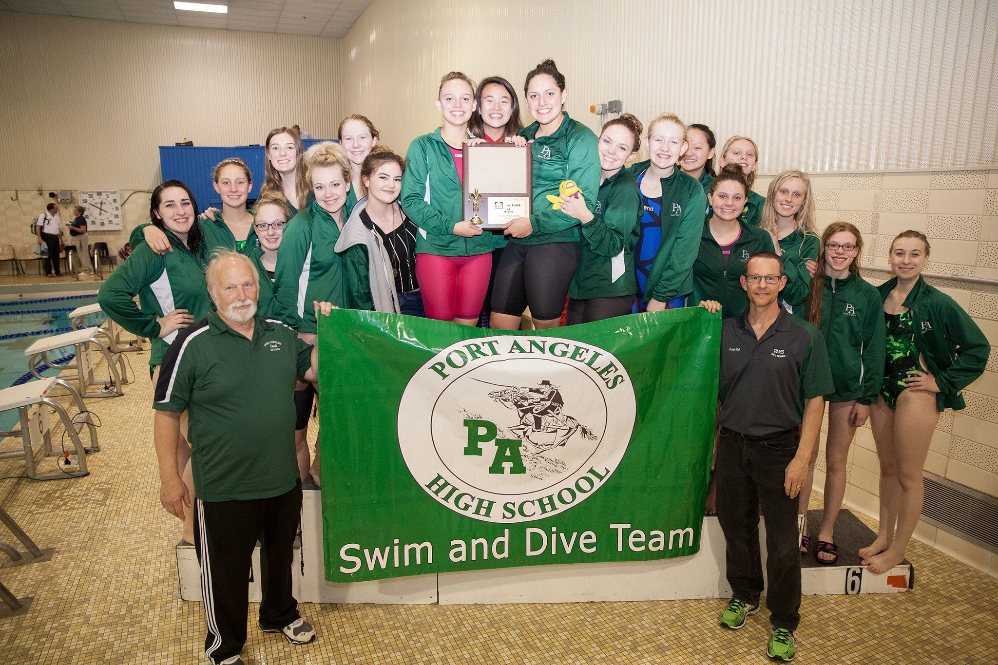 The Port Angeles girls’ swim team celebrates after winning the West Central District 3 championship Saturday.