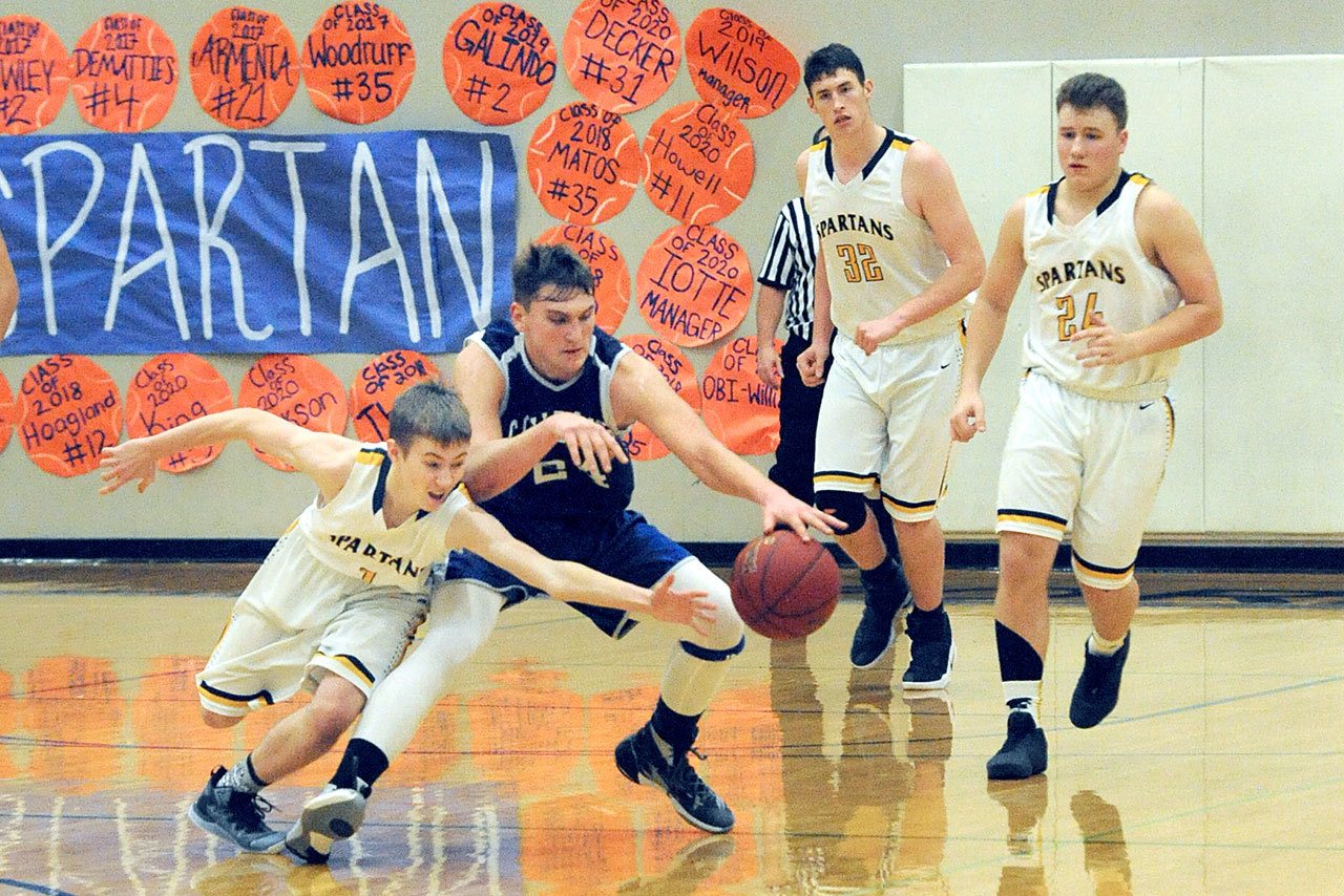 Lonnie Archibald/for Peninsula Daily News                                Forks’ Seth Johnson (1) goes for the steal against Chimacum’s Devyn Winkley (24) while the Spartans’ Marky Adams (32) and Cort Prose (24) look on.
