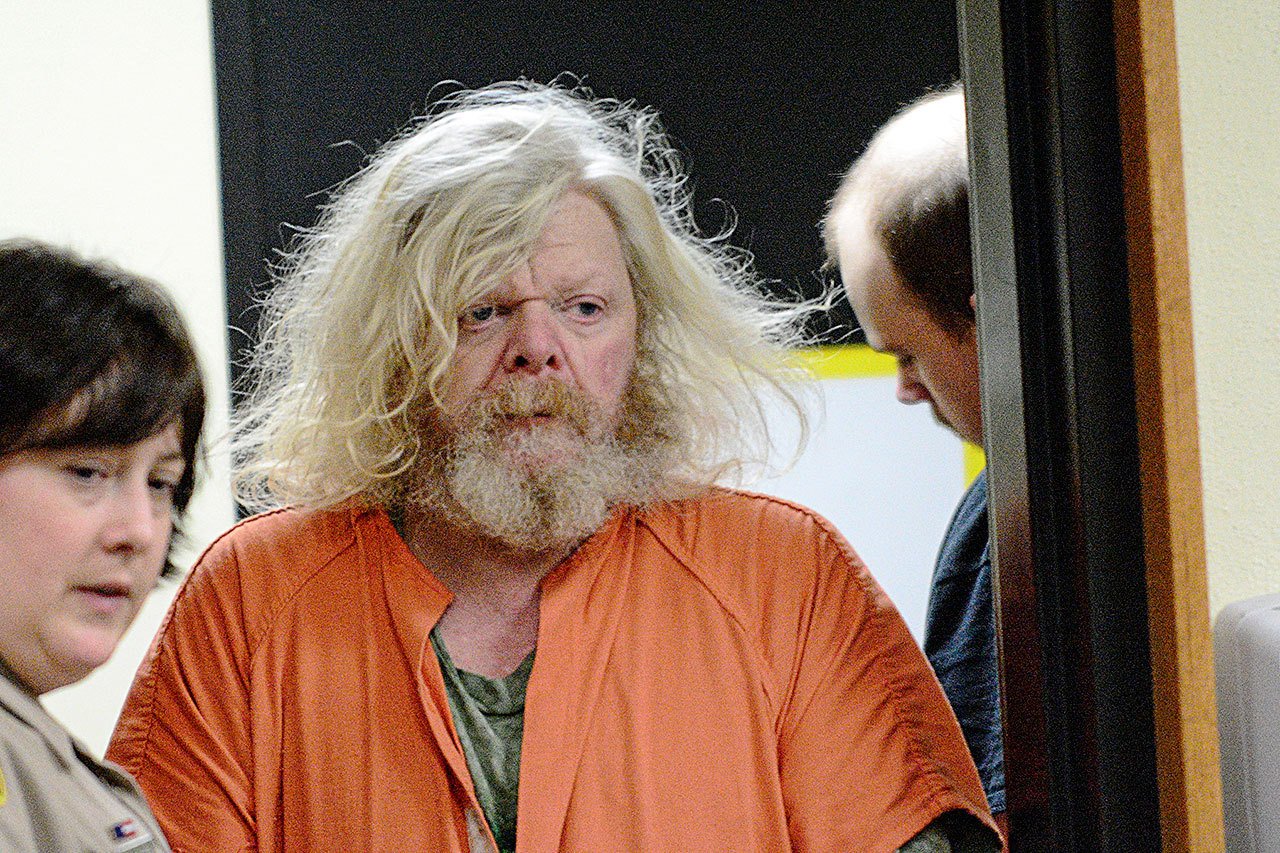 Andrew Helman, 58, accused of setting fire to his own home, is escorted into Clallam County Superior Court on Wednesday. (Jesse Major/Peninsula Daily News)