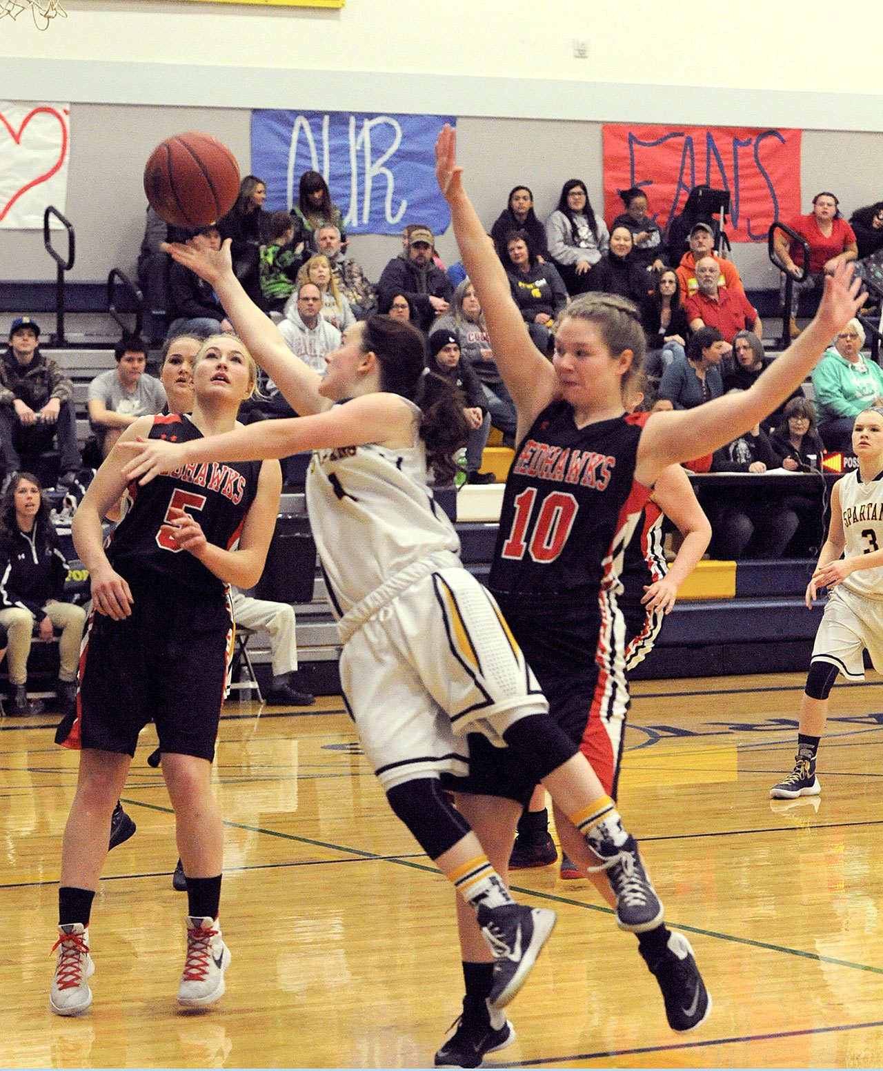 Lonnie Archibald/For the Peninsula Daily News                                Spartan Skyler DeMatties puts up a shot between Redhawks Kaitlyn Meek and Cece Nielsen Friday night in Forks. Port Townsend came back from a 10-point deficit in the closing minutes to defeat Forks 48 to 41.