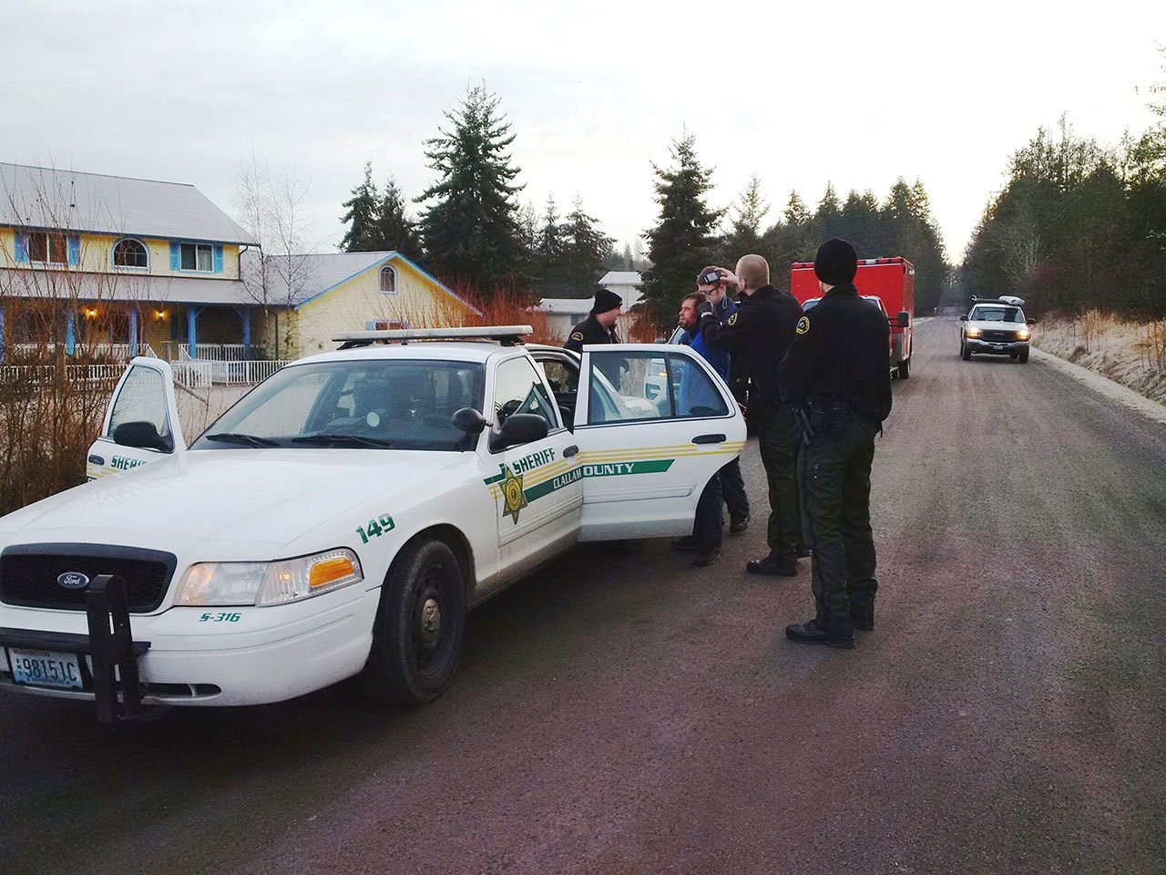 Cole Hall, second from left, is photographed after his arrest by Clallam County Sheriff’s Deputy Mark Millet, second from right. Deputy Andrew Wagner, Medic Joel Bower and Deputy Chris Moon, from left, look on. (Clallam County Sheriff’s Office)