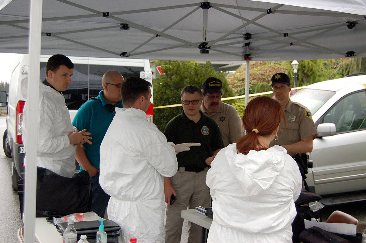 Representatives with the Clallam County Sheriff’s Office and Coroner’s Office investigate the death of Cynthia Little in Sunland on Thursday. (Matthew Nash/Olympic Peninsula News Group)