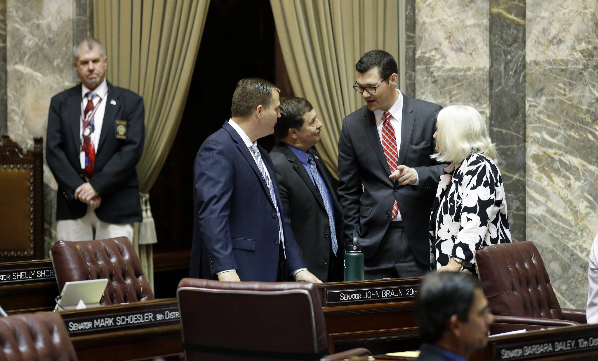From left, Sen. John Braun, R-Centralia; Sen. Mark Schoesler, R-Ritzville; Sen. Joe Fain, R-Auburn; and Sen. Randi Becker, R-Eatonville, confer on the Senate floor Friday at the Capitol in Olympia. (Ted S. Warren/The Associated Press)