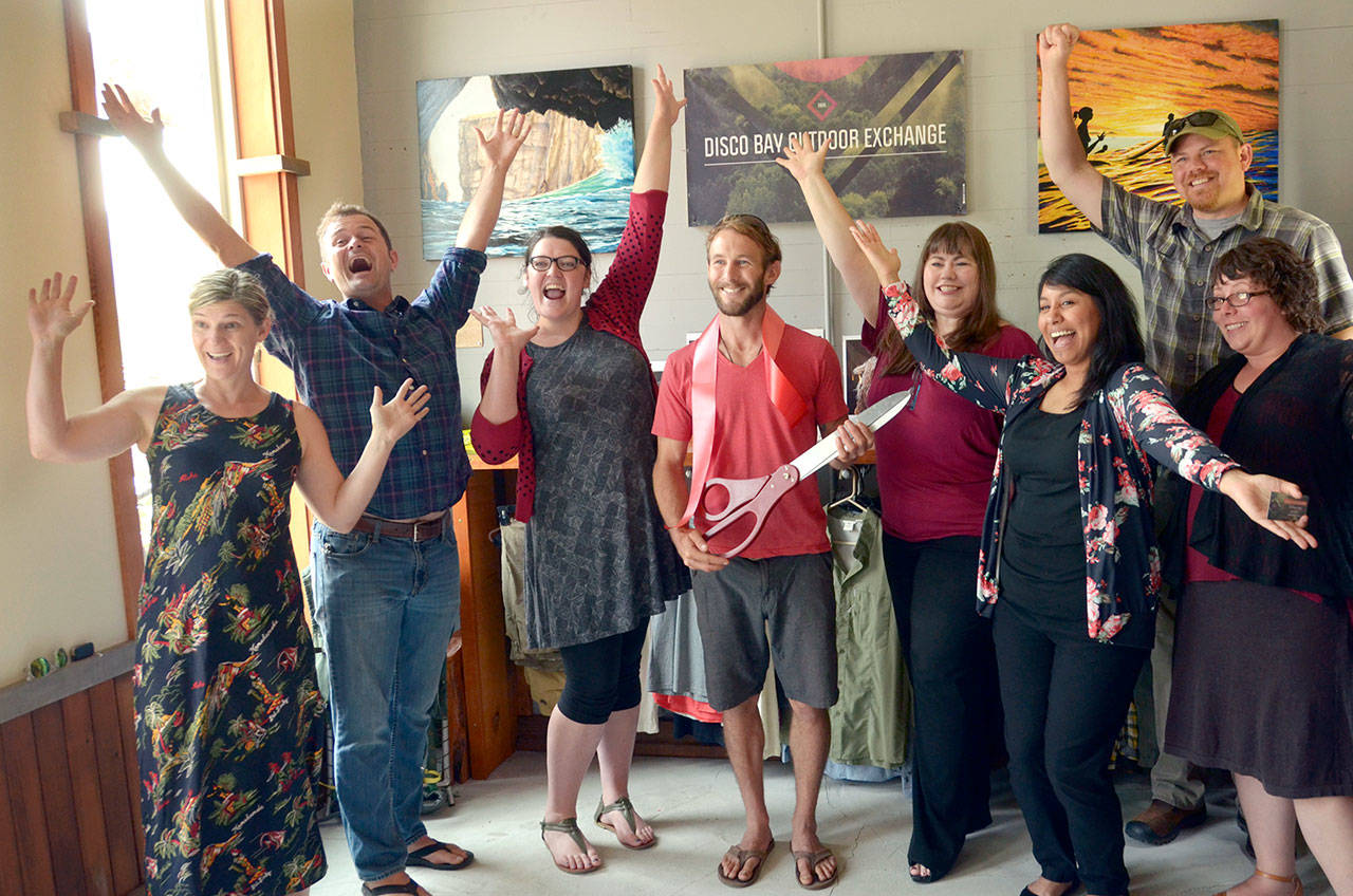 Tyler Meeks, center, owner of the new Discovery Bay Outdoor Exchange, celebrates his opening day with a ribbon-cutting Friday with members of the Jefferson County Chamber of Commerce. (Cydney McFarland/Peninsula Daily News)