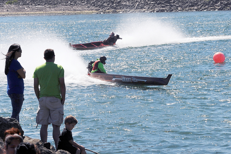 Outboard-powered dugout canoes round the south turn on the Quillayute River during Quileute Days 2015 in La Push. (Lonnie Archibald/for Peninsula Daily News)