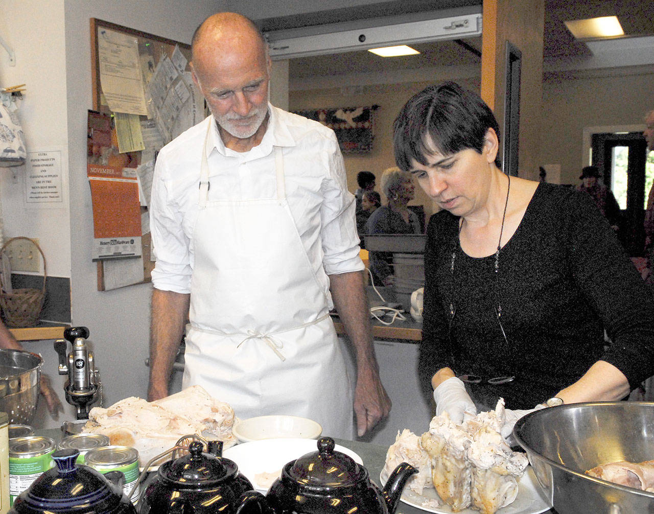 Elizabeth Bindschadler carves roasted turkey breasts in preparation for a big feast at St. Paul’s Episcopal Church in Port Townsend, assisted by Doug Hill. In addition to turkey, Tofurky was available as a vegetarian option. (Jeannie McMacken/for Peninsula Daily News)