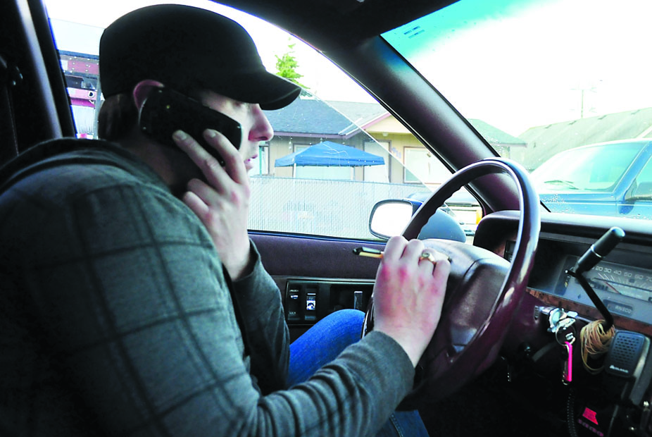 Blue Top Cab driver Christopher Cowell recieves a call from a customer while picking up another. Jesse Major/for Peninsula Daily News
