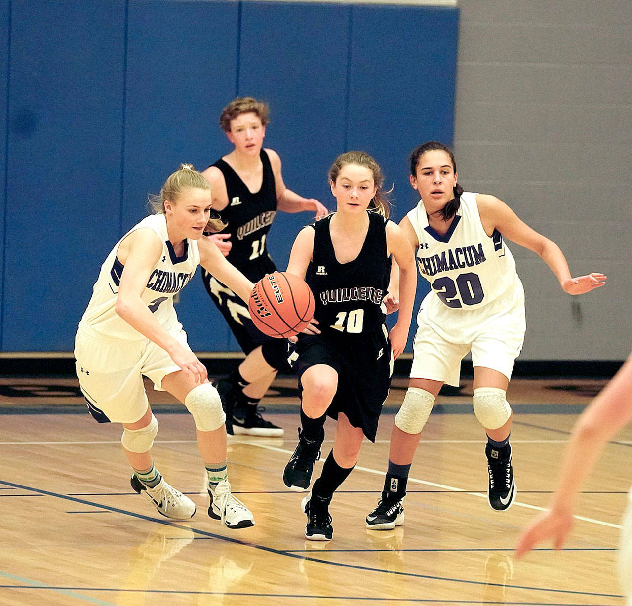 Steve Mullensky/for Peninsula Daily News Quilcene’s Brittney Beukes drives down court with Chimacum’s Grace Yaley and Mia McNair close on her heels during a Thursday night game in Chimacum.