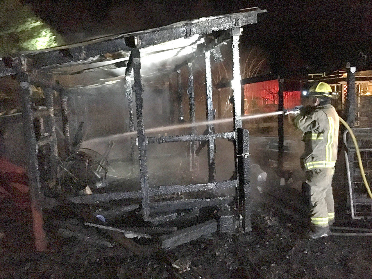 Lee Oman, a volunteer firefighter with Clallam County Fire District No. 3, sprays water on a chicken coop that caught fire on Jan. 9 west ofSequim. (Matthew Nash/Olympic Peninsula News Group)