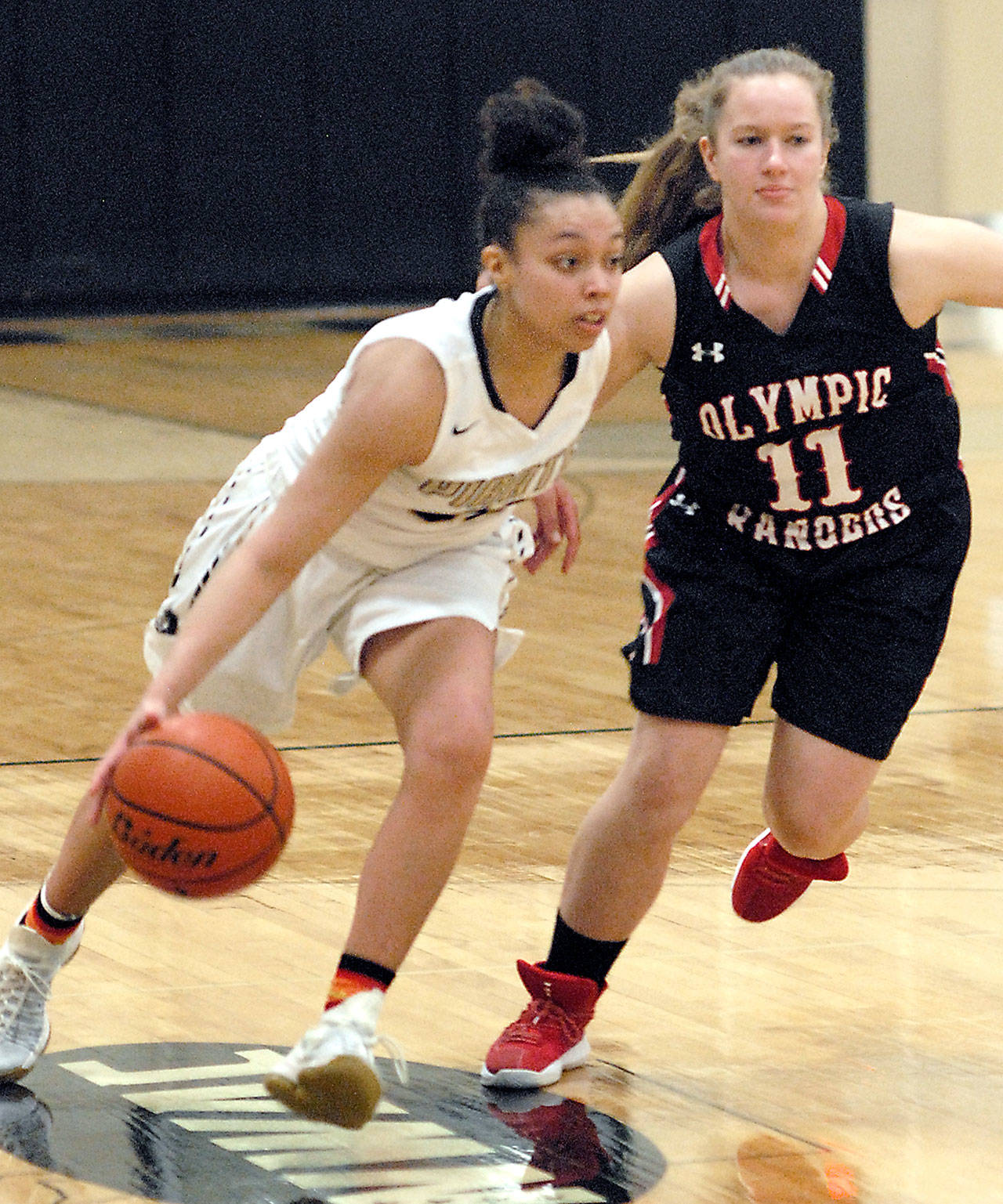 Peninsula’s Tiffany Smith, left, drives downcourt while guarded by Olympic’s Shanya Nisbet, a Chimacum graduate, Wednesday in Port Angeles. Keith Thorpe/Peninsula Daily News