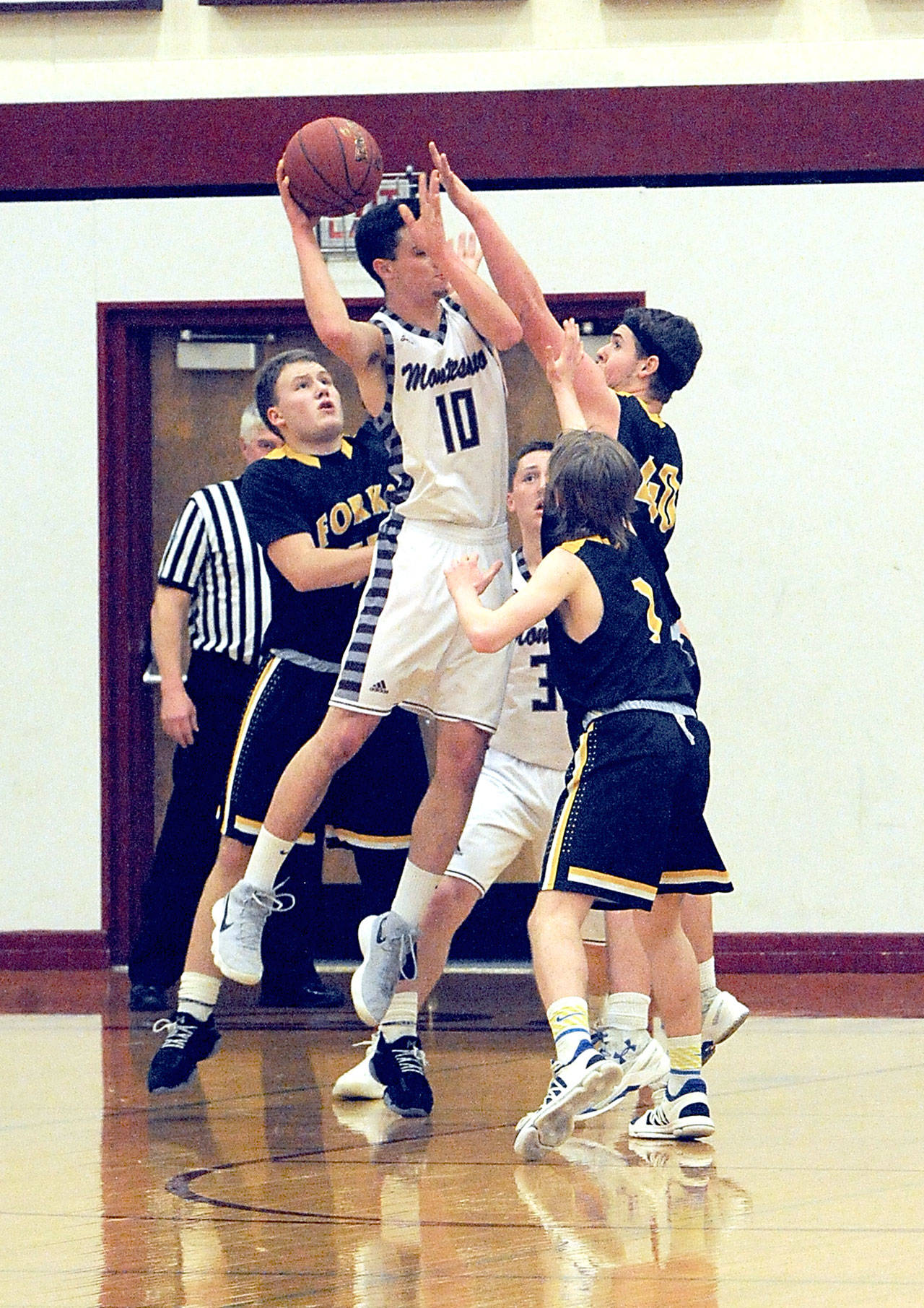 From left, Forks players Cort Prose, Scott Archibald and Seth Johnson pressure Montesano’s Trevor Ridgway. Lonnie Archibald/for Peninsula Daily News