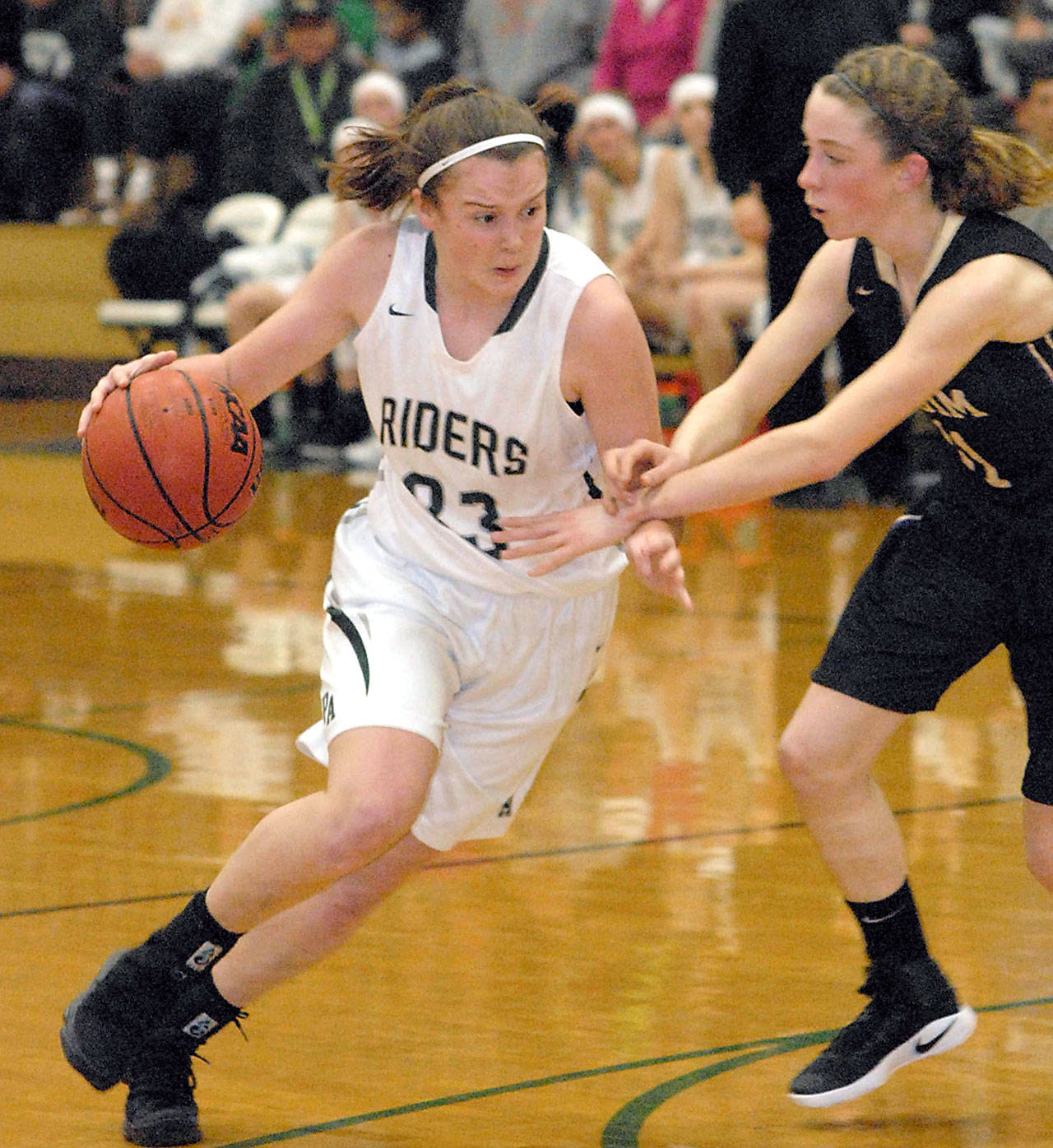 Keith Thorpe/Peninsula Daily News Port Angeles’ Jaida Wood, left, drives past Sequim’s Abby Schroeder during their Dec. 13, game in Port Angeles.