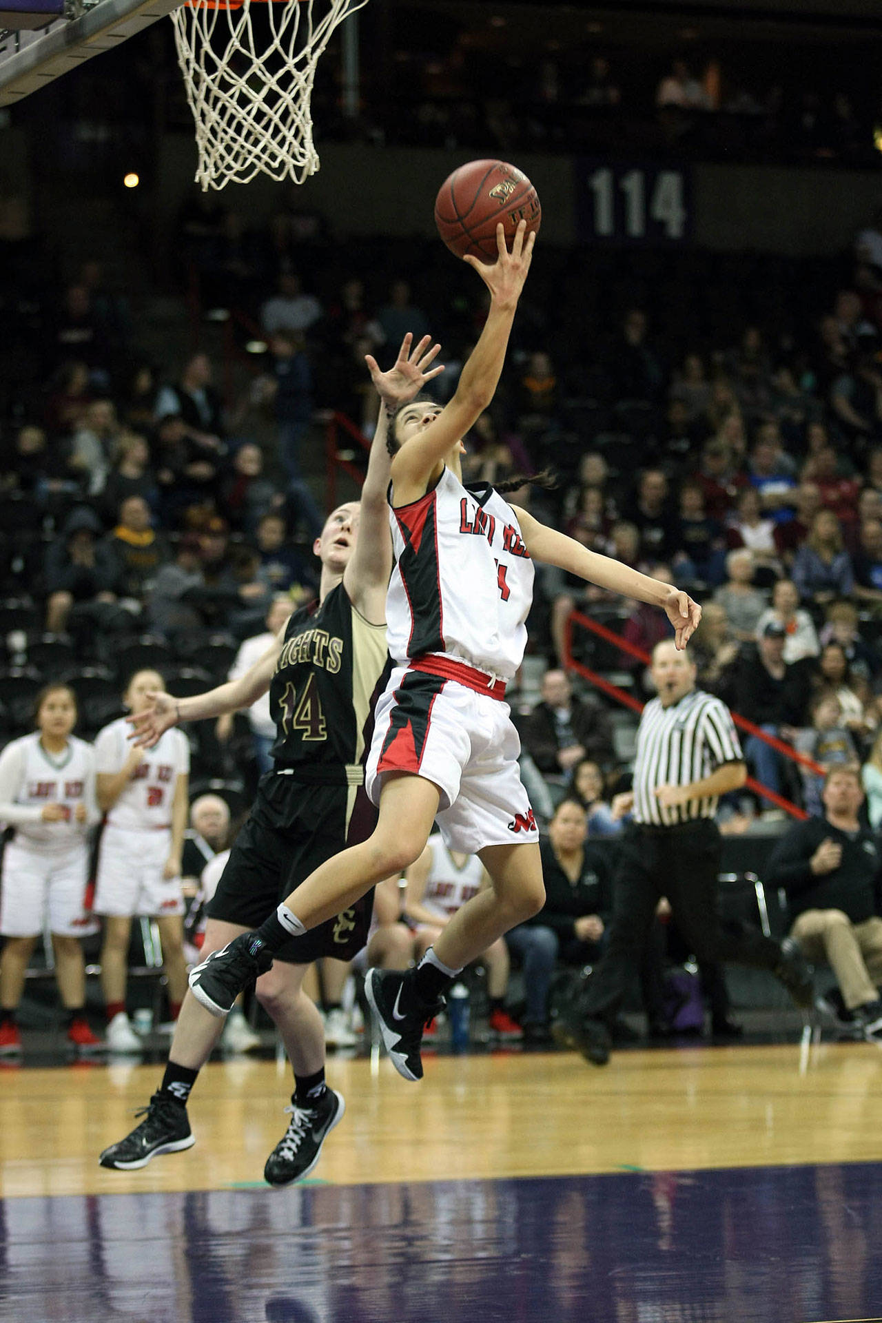 Neah Bay’s Lalia Greene dribbles baseline, beating Alyssa Martin from Sunnyside Christian with a reverse lay-up in Saturday’s 1B third-place game. (David Willoughby/for Peninsula Daily News)