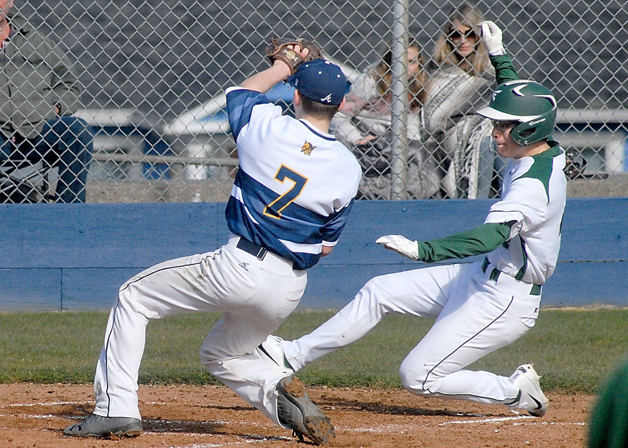 Port Angeles’ Gavin Guerrero, right, slides safely into home as Aberdeen pitcher Jaxson Larson waits for the ball after a wild pitch slipped past catcher Josh Germeaux in the second inning on Saturday at Port Angeles Civic Field.                                Keith Thorpe/Peninsula Daily News