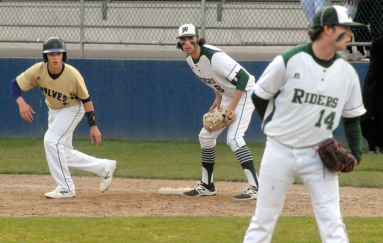 Sequim’s Michael Young, left, takes a lead off as he watches Port Angeles pitcher Brady Shimko, right, as Roughrider first baseman Bo Bradow waits for delivery in the first inning on Wednesday evening at Port Angeles Civic Field.                                Keith Thorpe/Peninsula Daily News