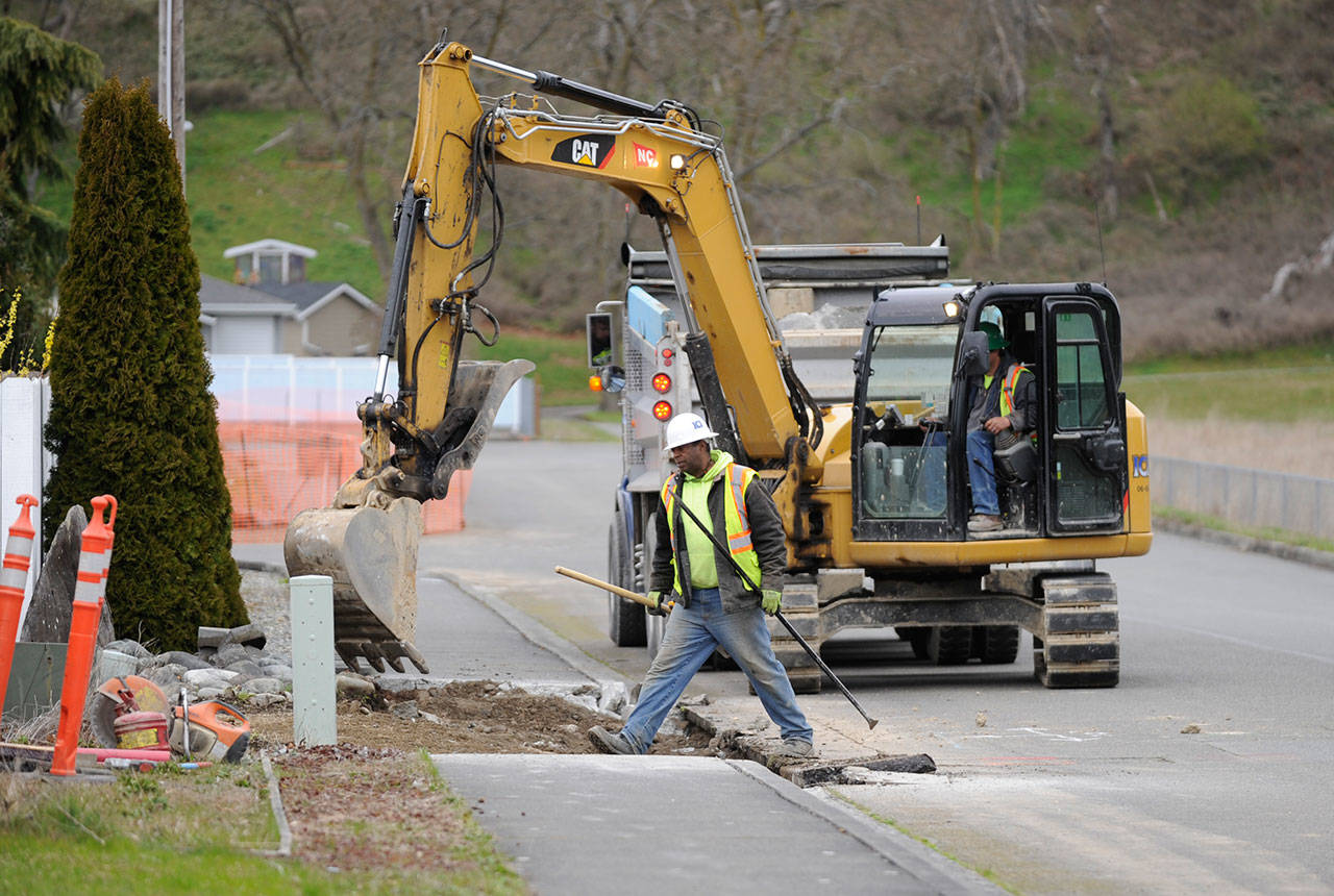 Workers with InterWest Construction Inc. work on installing new sidewalk stretches and ADA-compliant curbs recently. Funding for the project comes from Sequim’s Transportation Benefit District. (Michael Dashiell/Olympic Peninsula News Group)