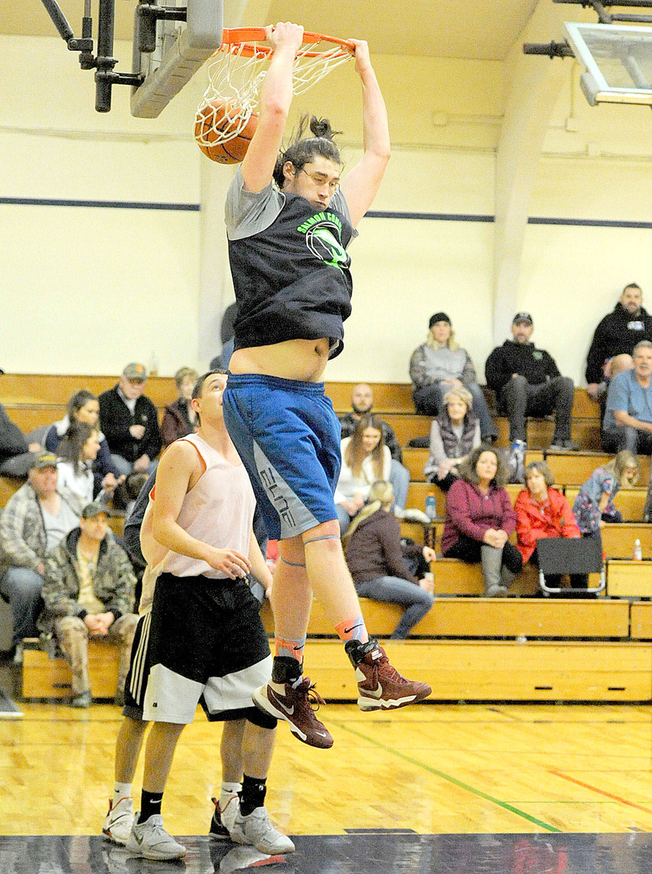 Former Spartan and current Peninsula College Pirate Marky Adams returned to the Spartan Gym last month with the Olympic Sporting Goods to participate in the Nate Crippen Memorial Scholarship Tournament. Pictured here Adams completes a reversed dunk against Stratton of Kennewick composed of Kennewick, Forks and other area players. The Olympic Sporting Goods defeated Stratton 57-44. (Lonnie Archibald/for Peninsula Daily News)