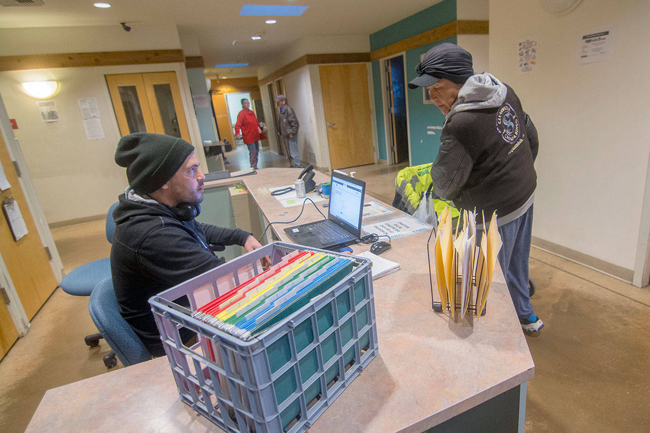 Michelle Descharne signs into Serenity House of Clallam County’s night-by-night shelter Tuesday. (Jesse Major/Peninsula Daily News)