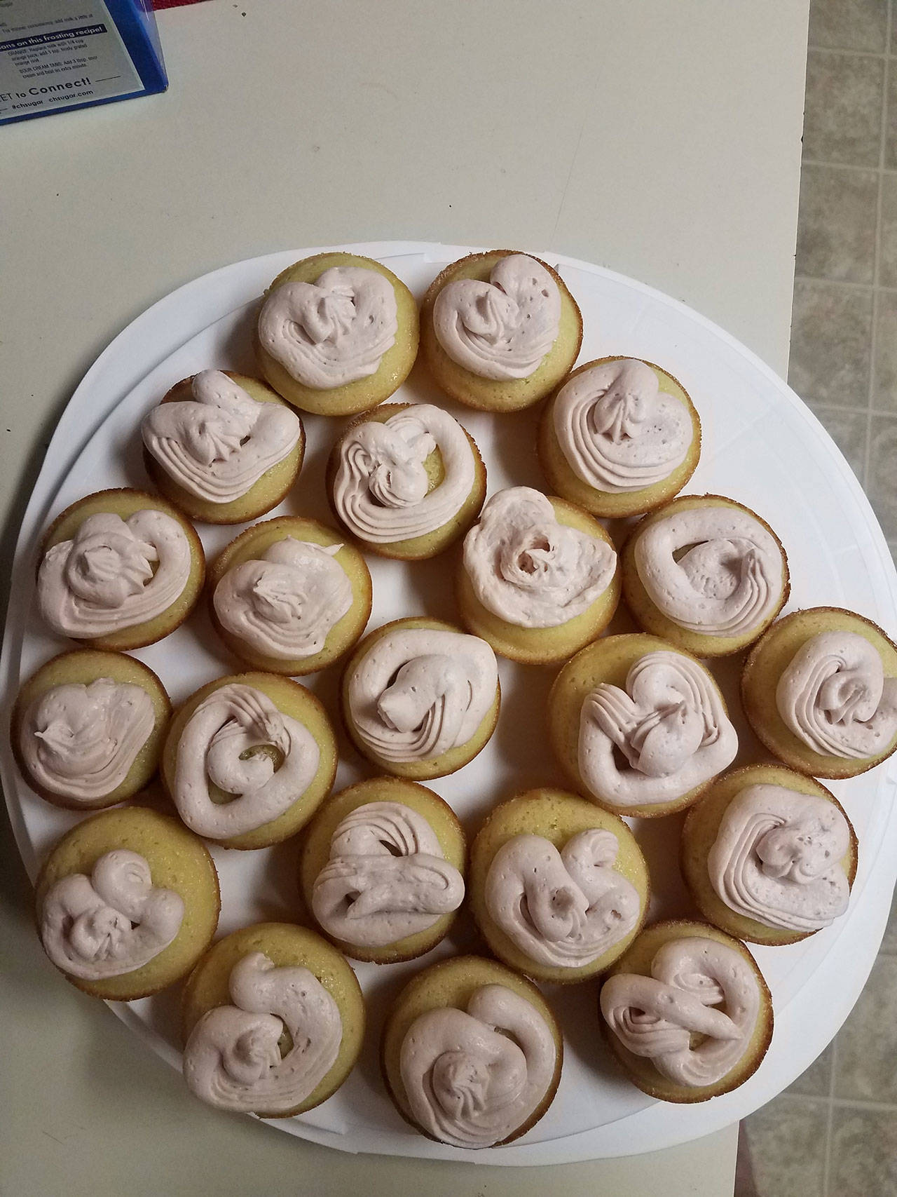 Lemon cupcakes with strawberry frosting await eating. (Emily Hanson/Peninsula Daily News)