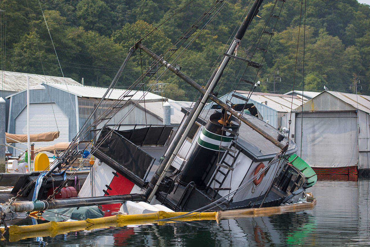 Booms surround a boat at the Port Angeles Boat Haven on Monday. (Jesse Major/Peninsula Daily News)