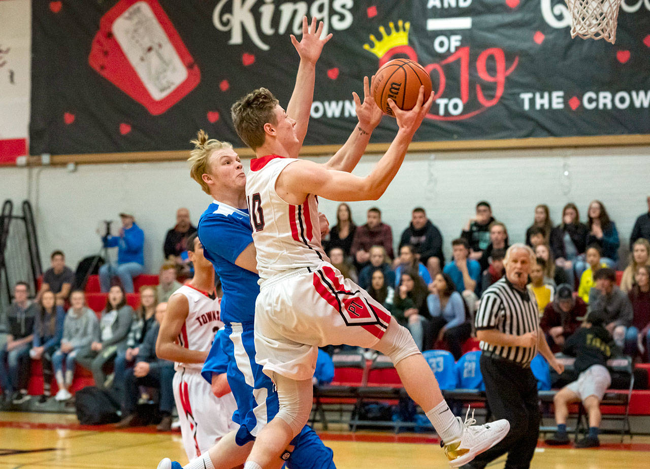 Steve Mullensky/for Peninsula Daily News                                Port Townsends Cole Crawford jumps past Chimacums Cody Clark and goes up for a layup during a game in Port Townsend on Friday night.
