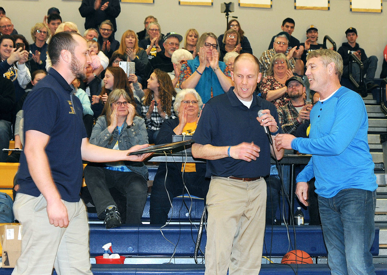 Lonnie Archibald/for Peninsula Daily News Forks High School girls head basketball coach David Hurn and head boys basketball coach Rick Gooding present former Spartans star Ron Bagby with a plaque recognizing Bagby’s induction into the Spartan Basketball Hall of Fame.