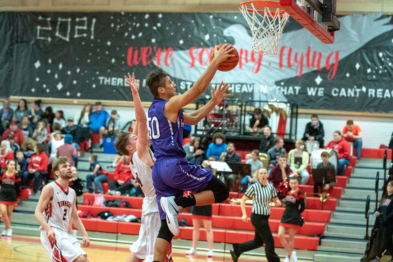 Sequim’s Hayden Eaton goes up for a pair of points despite the defense of Port Townsend’s Nico Winegar during the Wolves’ win over the Redhawks on Tuesday.                                Steve Mullensky/for Peninsula Daily News