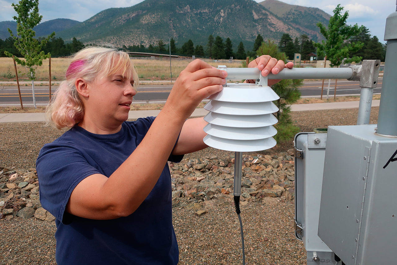 Anita Thompson, a forester with the Apache-Sitgreaves National Forest in eastern Arizona, checks an air quality monitor outside an emergency operations center in Flagstaff, Ariz. (Felicia Fonseca/The Associated Press)