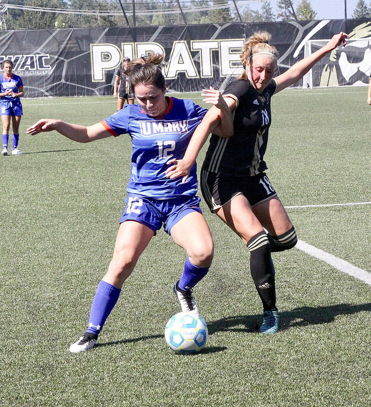 University of Mary’s Malia Brudvik (12) and Peninsula College’s Kyrsten McGuffey (18) fight for the ball Monday at Wally Sigmar Field. Brudvik played for the Pirates back in 2016 when they won the NWAC championship and McGuffey is a Port Angeles High School graduate. (Dave Logan/for Peninsula Daily News )