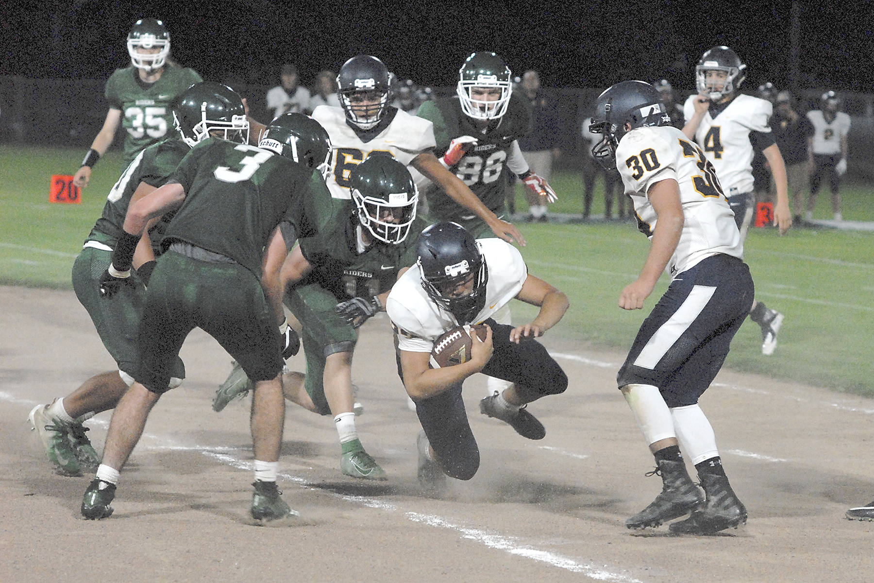 Forks running back Ricardo Barragan, center, dives for yardage during Friday’s win over Port Angeles.