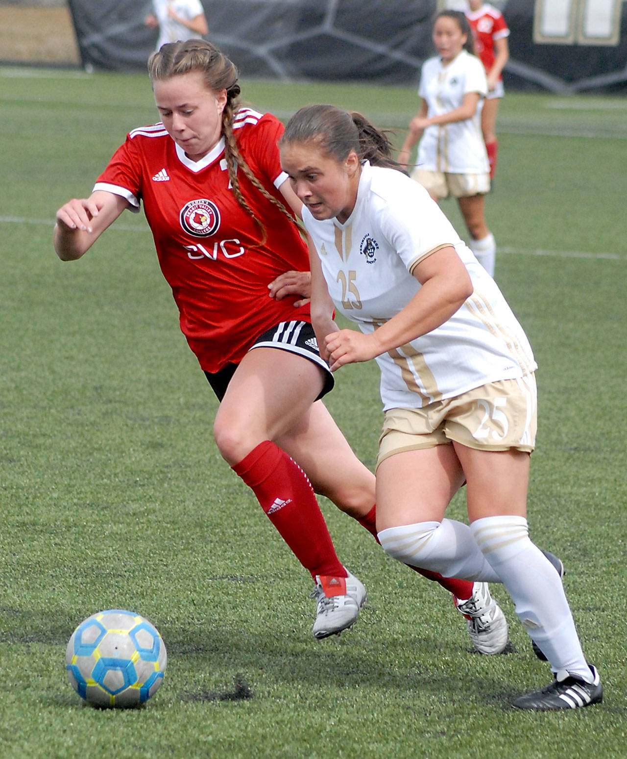 Keith Thorpe/Peninsula Daily News Peninsula’s Sam Oliveira, right, races for the ball with Skagit Valley’s Alexandra McBeath on Wednesday at Wally Sigmar Field in Port Angeles.