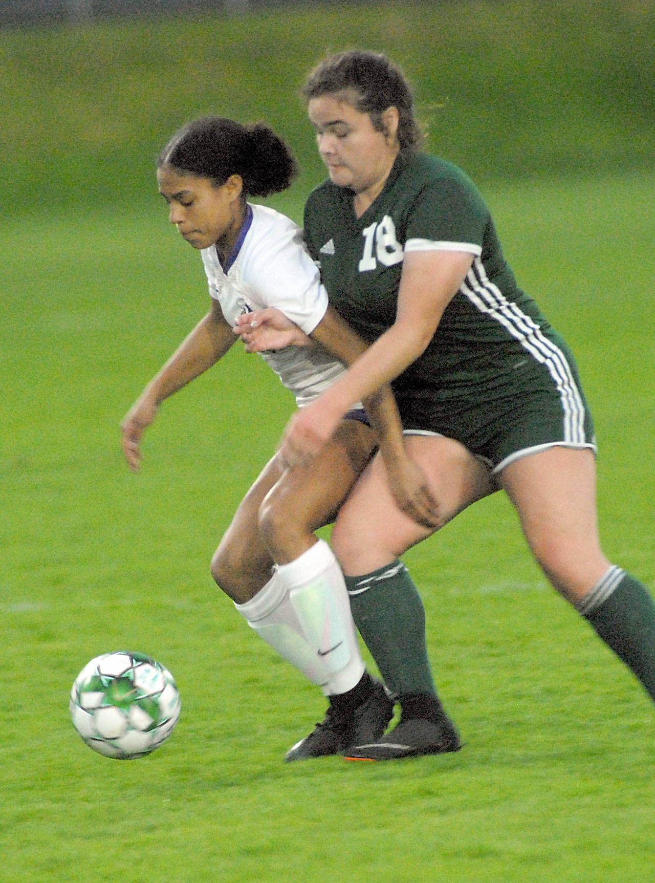 Keith Thorpe/Peninsula Daily News North Kitsap’s Kamora McMillian, left, and Port Angeles’ Kiana Watson-Charles battle for ball control on Thursday night at Port Angeles Civic Field.