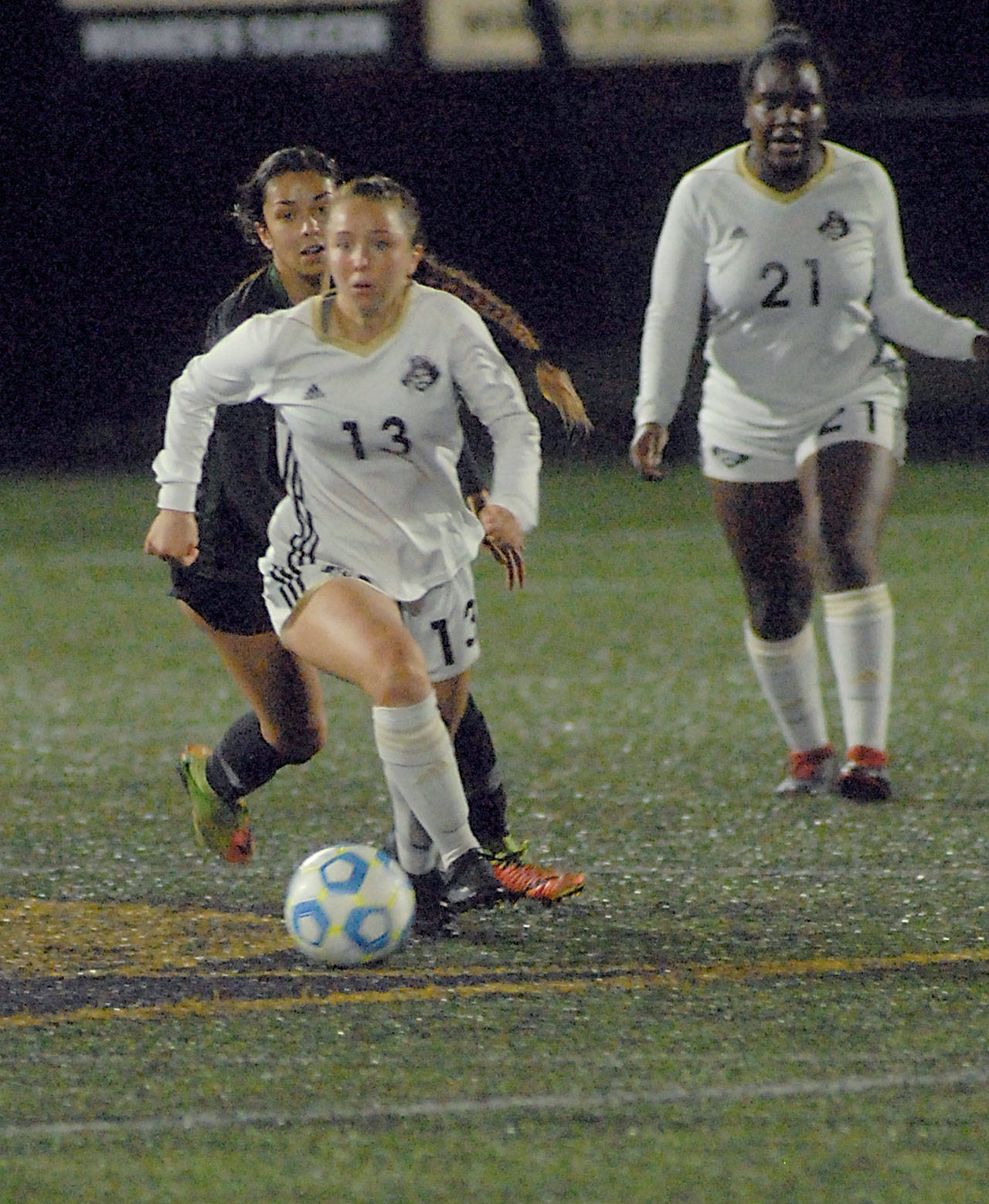 Peninsula’s Grace Hipke, front, outruns Shoreline’s Julia Olvera as Hipke’s teammate Tommylia Dunbar, right, looks on during Wednesday night’s match at Wally Sigmar Field in Port Angeles. (Keith Thorpe/Peninsula Daily News)