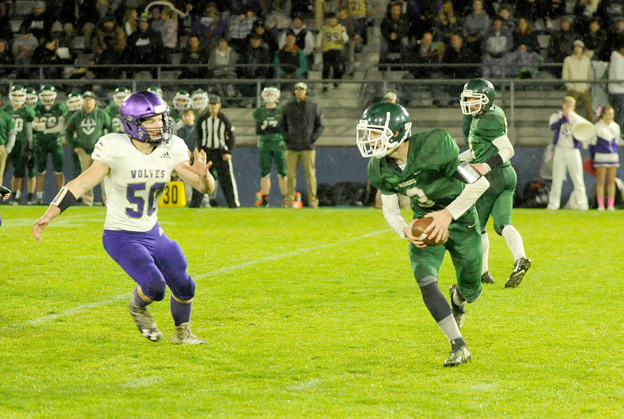 Sequim’s Isaiah Cowan pursues Port Angeles quarterback Nolan Hughes during the Wolves’ 26-0 Rainshadow Rumble victory over the Roughriders. (Michael Dashiell/Olympic Peninsula News Group)