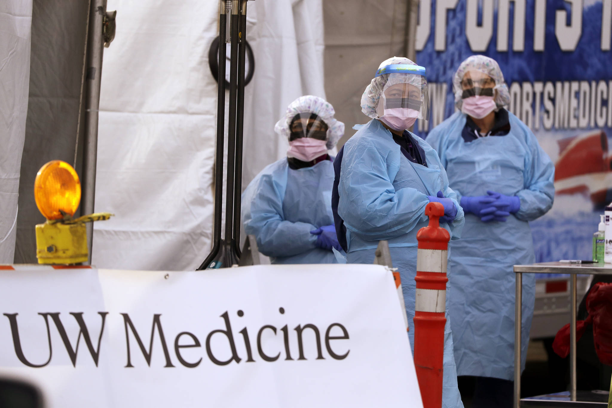 Medical personnel wait for a driver to pull up at a drive-through COVID-19 testing station for University of Washington Medicine patients Tuesday, March 17, 2020, in Seattle. The appointment-only drive-through clinic began a day earlier. Health authorities in Washington reported more COVID-19 deaths in the state that has been hardest hit by the outbreak. (Elaine Thompson/The Associated Press)