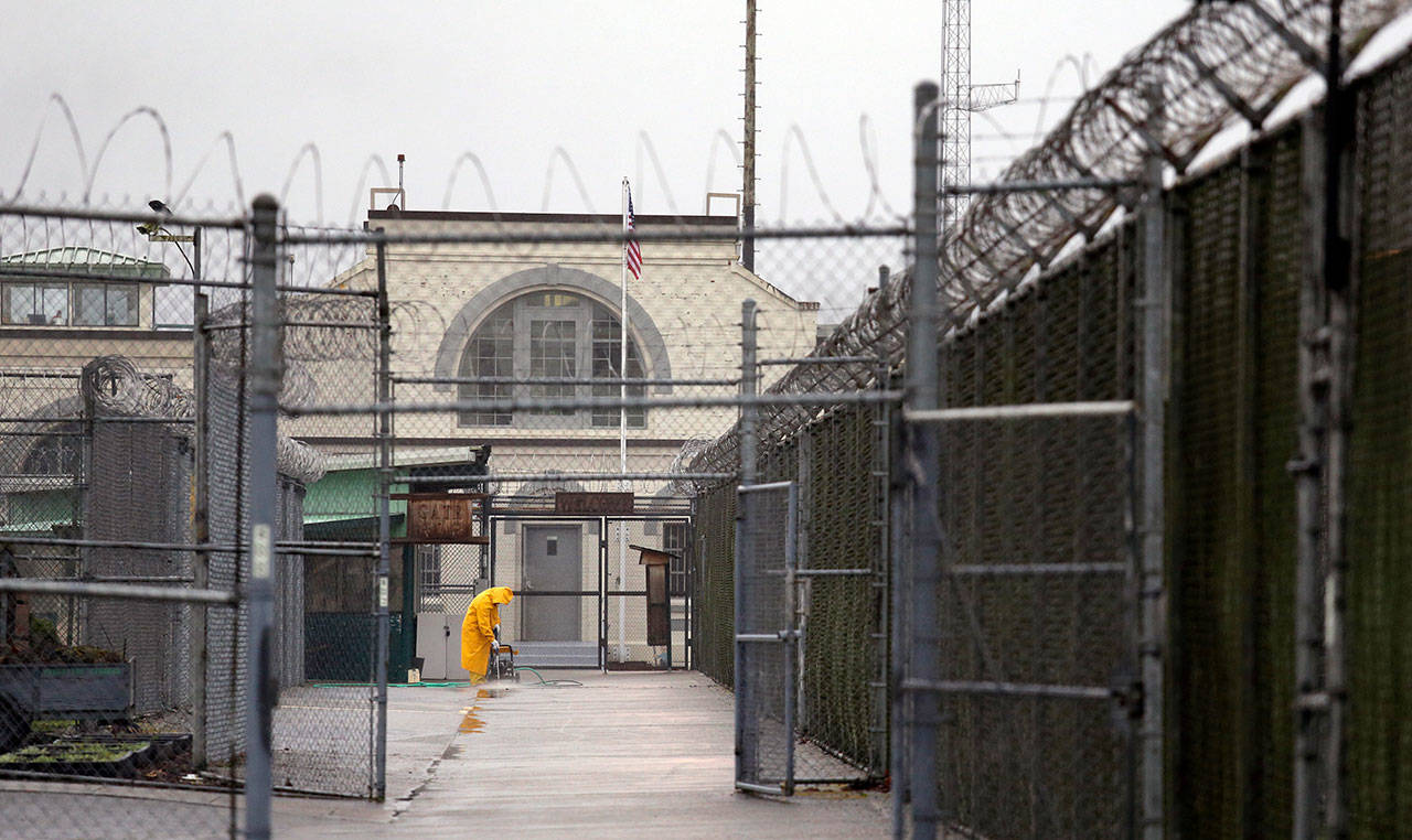 In this Jan. 28, 2016, file photo, a man does maintenance work between razor wire-topped fences at the Monroe Correctional Complex in Monroe, Wash. Inmates at the prison filed a motion Thursday, April 9, 2020, with the Washington state Supreme Court asking it to order Gov. Jay Inslee and Department of Corrections Secretary Stephen Sinclair to release inmates who are 60 years old or older, those with underlying health conditions, and any who are close to their release date after almost a dozen people at the prison tested positive for the new coronavirus. (Elaine Thompson/The Associated Press file)