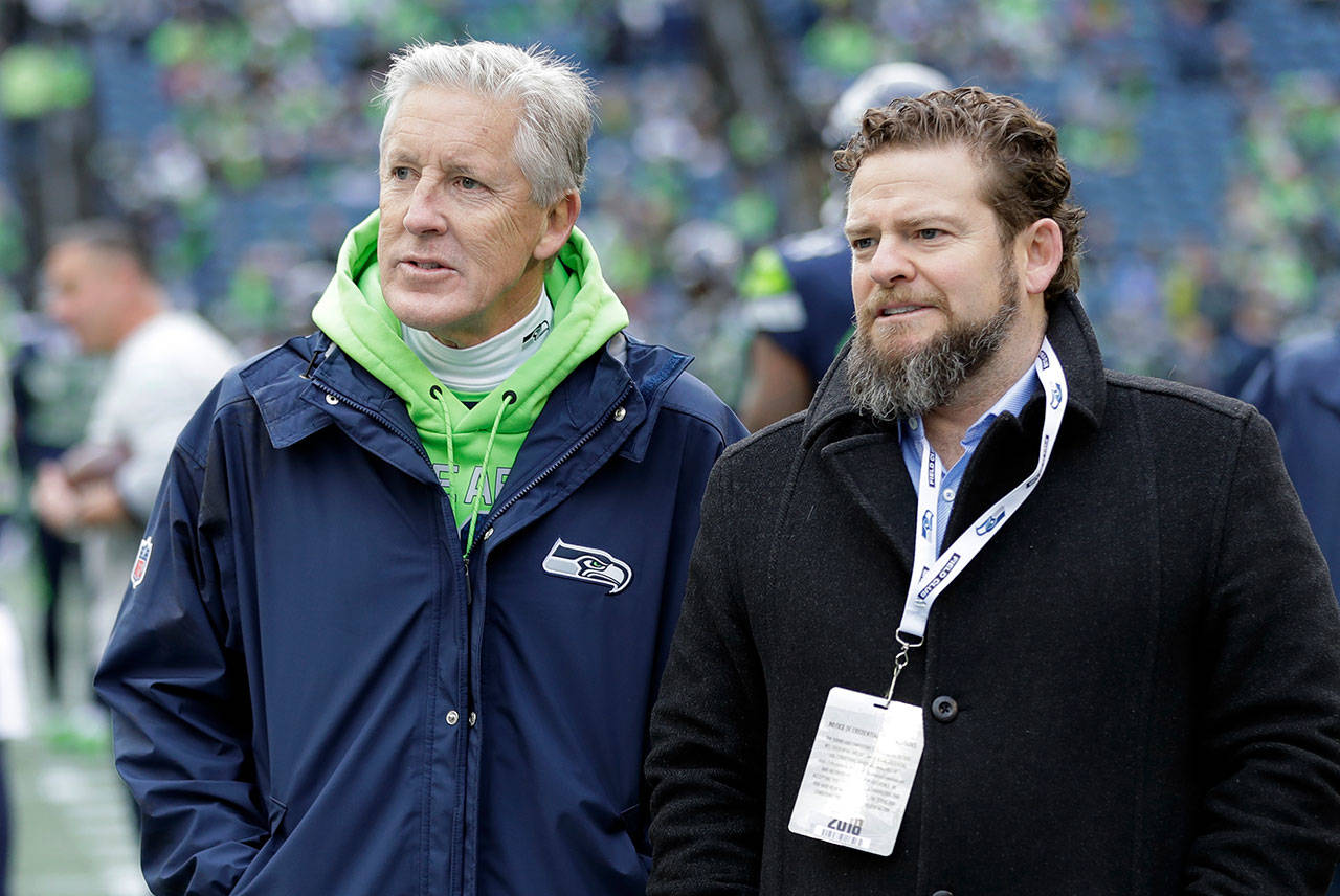 In this Dec. 30, 2018, file photo, Seattle Seahawks coach Pete Carroll, left, talks with general manager John Schneider before the team’s NFL football game against the Arizona Cardinals in Seattle. There is a clear and obvious need for the Seahawks to address along the defensive line and it happens to be one of the deeper positions of talent in the entire draft. That may be far too simplistic and straightforward for Schneider and Carroll. Schneider is always good for a few surprises in the draft, and more than a couple of trades. So, while it seems addressing the pass rush — especially with the continuing unknowns around Jadeveon Clowney — is the obvious direction for Schneider and the Seahawks, it’s never that clear with Seattle. (Ted S. Warren/Associated Press file)