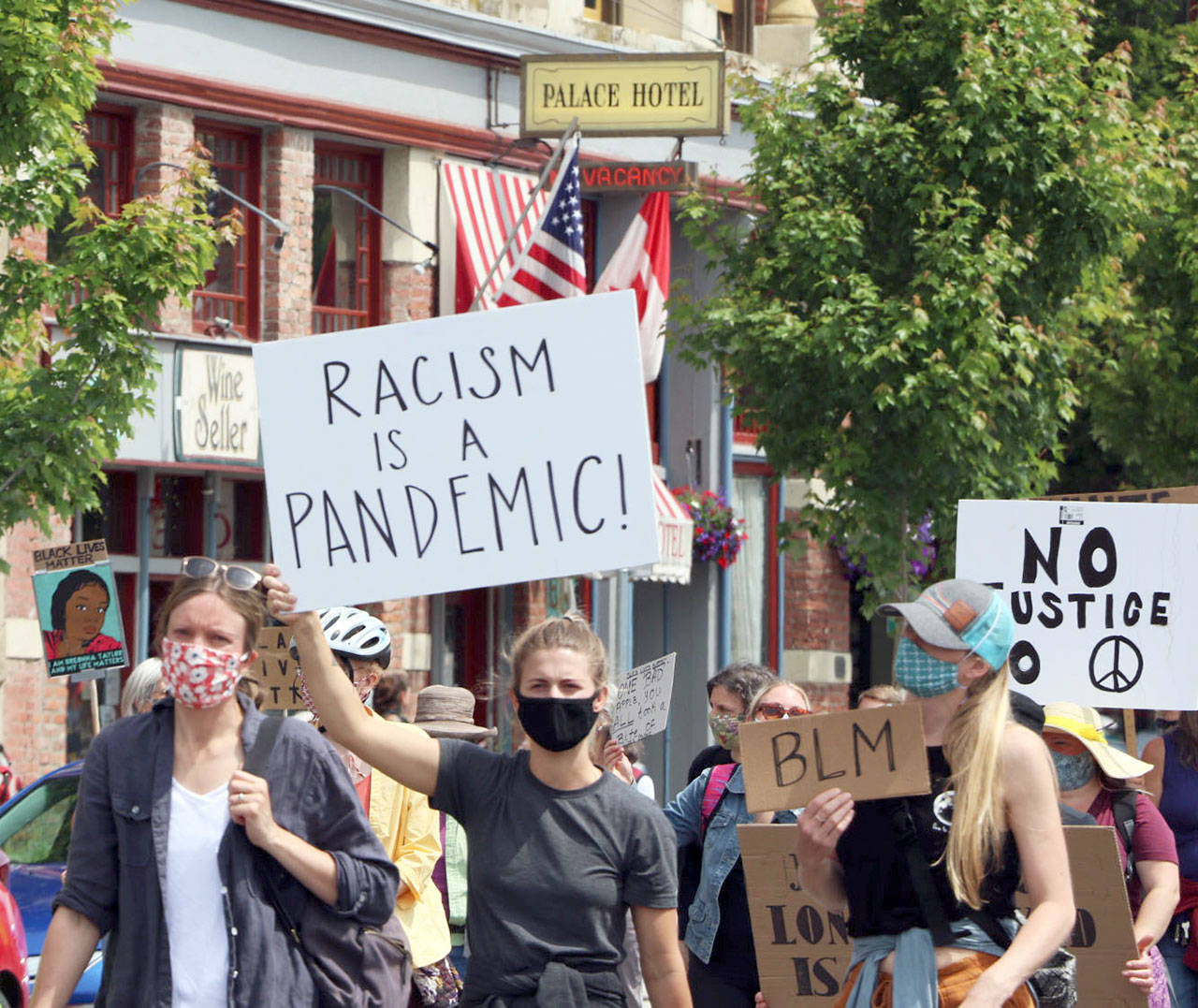 Ken Park/Peninsula Daily News “Racism is a Pandemic” reads the sign carried by a masked participant in Port Townsend’s Juneteenth rally and march, which drew more than 1,000 people.