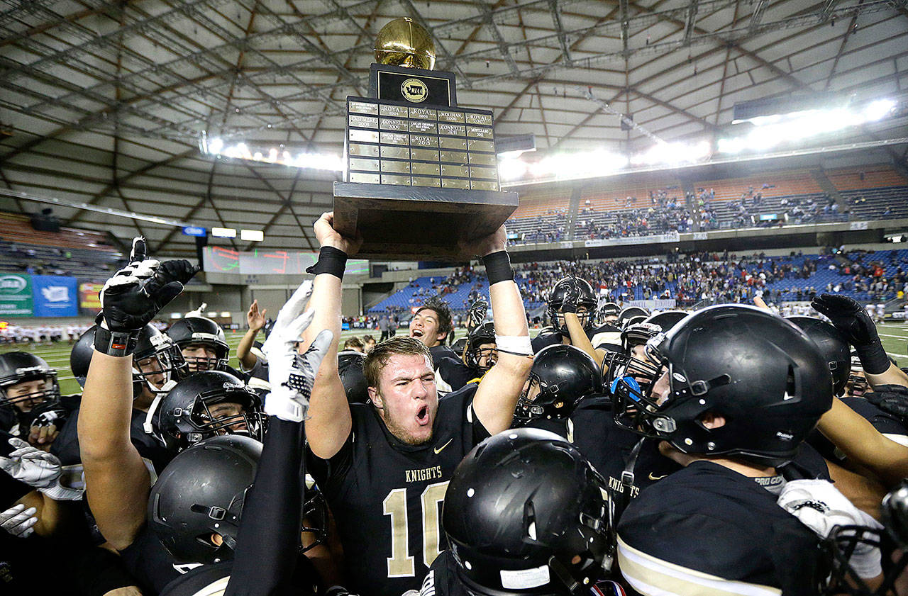 In this Dec. 3, 2016, file photo, Royal quarterback Kaden Jenks (10) celebrates with the trophy after Royal beat Connell in the Washington Div. 1A high school football championship in Tacoma, Wash. The overwhelming uncertainty of whether high school sports can go forward in the fall of 2020 amidst the continued COVID-19 pandemic is a constant refrain among administrators and decision makers as the clock ticks closer to the start of the 2020-21 school year with little clarity in place for an obvious and safe path moving forward for athletics. (Ted S. Warren/Associated Press file)