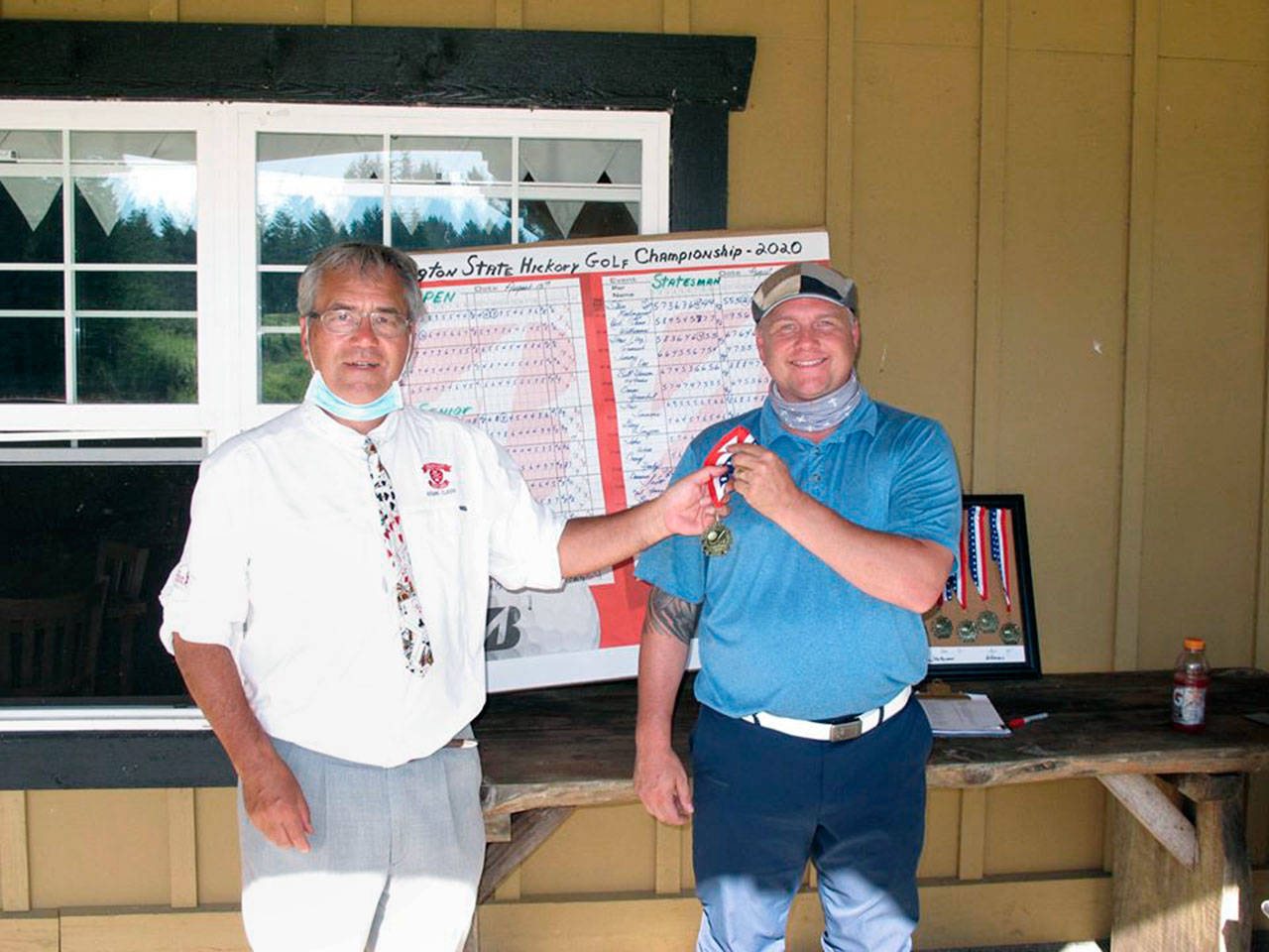 Port Townsend’s Gabriel Tonan, right, accepts medalist honors as Washington State Hickory Golf Tournament Champion from Martin Pool of the Northwest Hickory Players after he won the event at Trophy Lake Golf & Casting Club in Port Orchard on Saturday, Aug. 15, 2020.