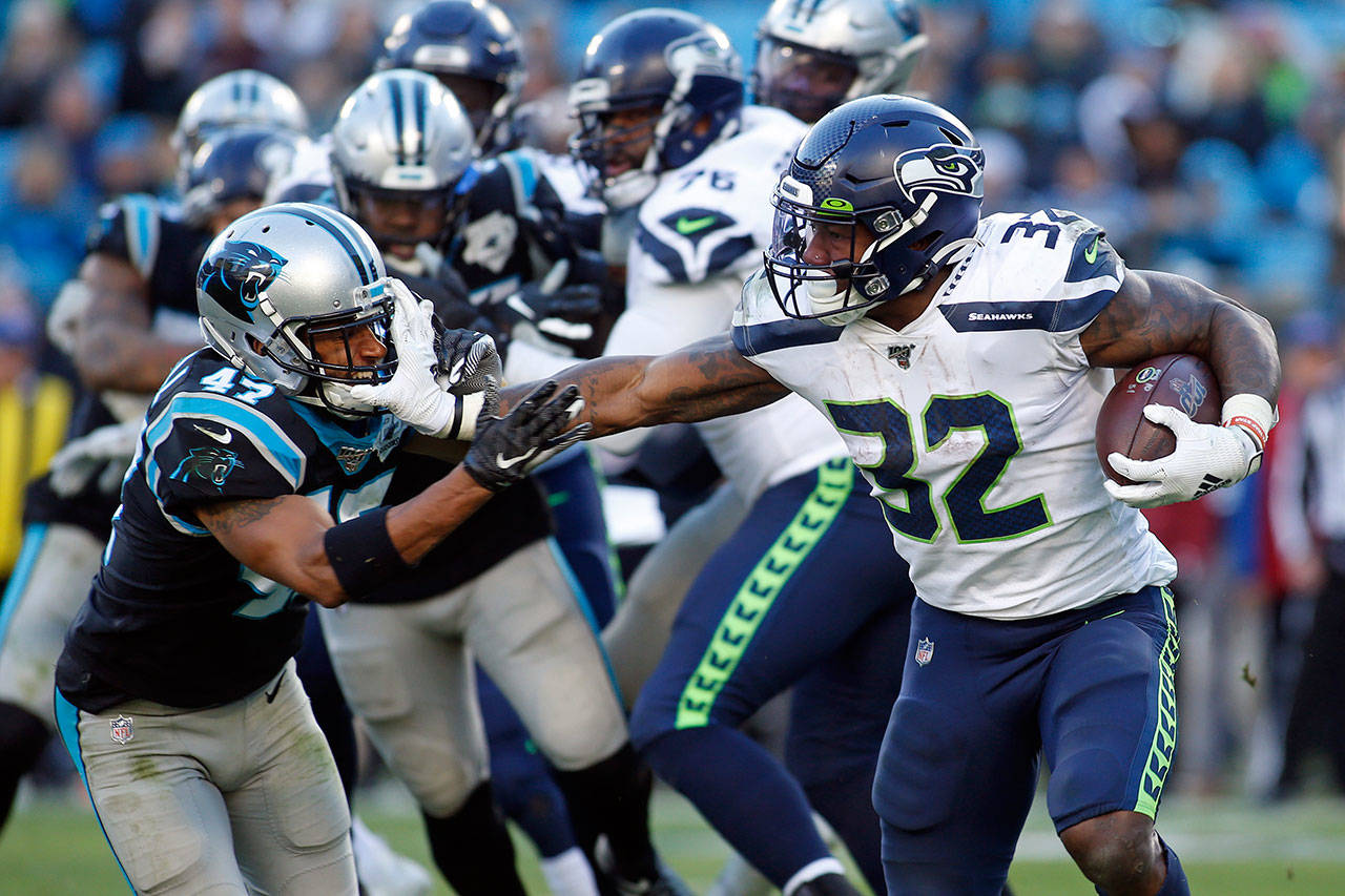 Seattle Seahawks running back Chris Carson (32) runs while Carolina Panthers defensive back Ross Cockrell (47) chases during the second half of an NFL football game in Charlotte, N.C., on Sunday, Dec. 15, 2019. (Brian Blanco/Associated Press file)