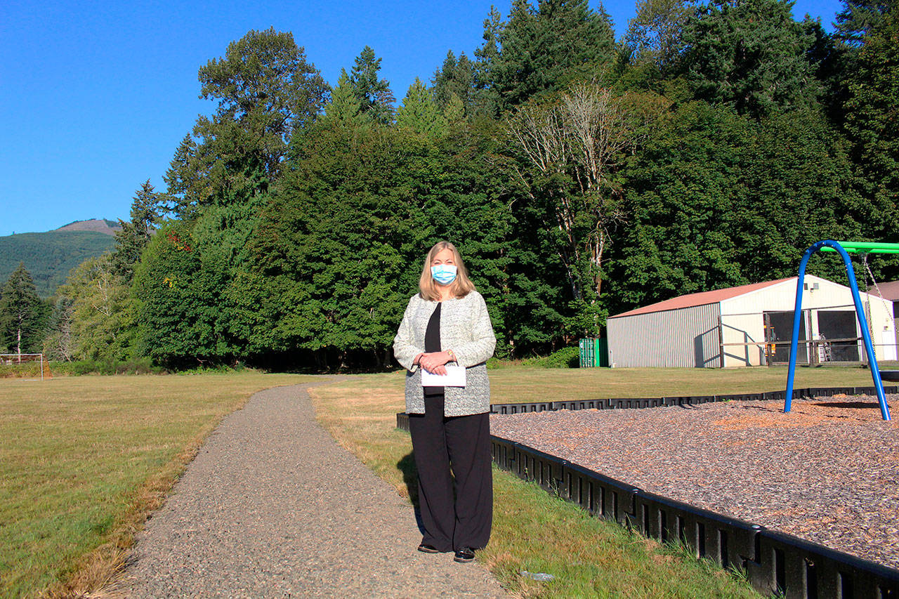 Brinnon School District Superintendent Trish Beathard stands on the district’s new walking/running path that was installed over late spring and summer with funding received from a state grant. To her right is the upgraded play area that the district completed last summer with a separate grant award from the same state funding source. (Zach Jablonski/Peninsula Daily News)