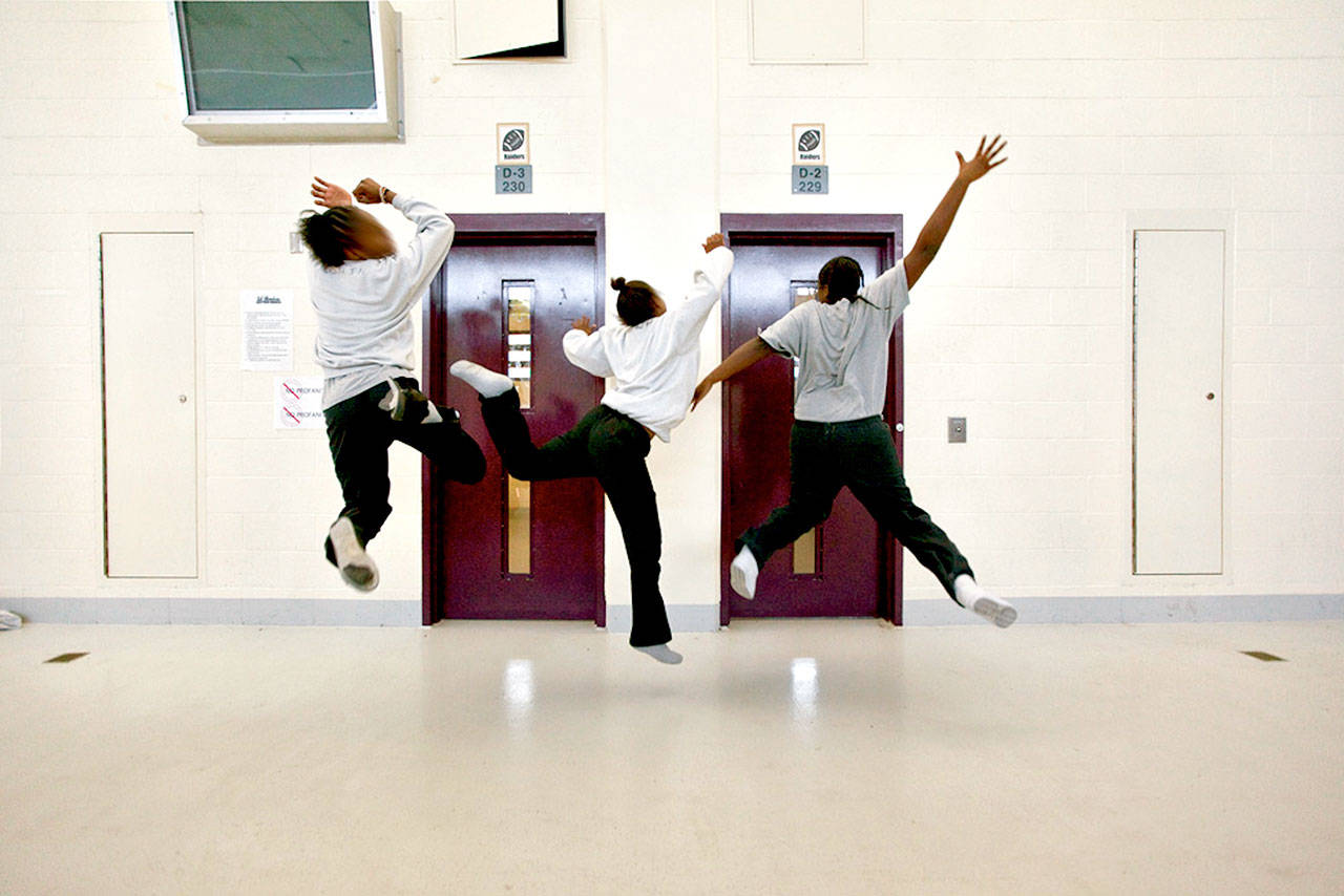 Three girls dance while other girls drum on the tables in Central Juvenile Hall, Los Angeles, Calif. There are 113 girls in this facility. (Richard Ross)