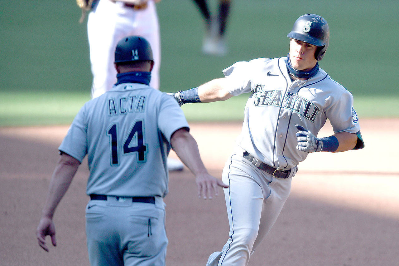 Seattle Mariners’ Dylan Moore (25) is congratulated by Manny Acta (14) after hitting a two-run home run against the San Diego Padres on Sunday, Sept. 20, 2020, in San Diego. (Denis Poroy/Associated Press)