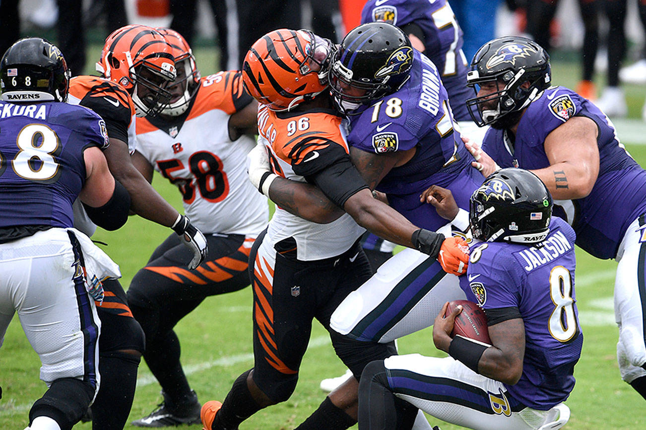 Cincinnati Bengals defensive end Carlos Dunlap (96) is able to sack Baltimore Ravens quarterback Lamar Jackson (8) in spite of being blocked by Ravens offensive tackle Orlando Brown (78) during the first half of an NFL football game, Sunday, Oct. 11, 2020, in Baltimore. (AP Photo/Nick Wass)