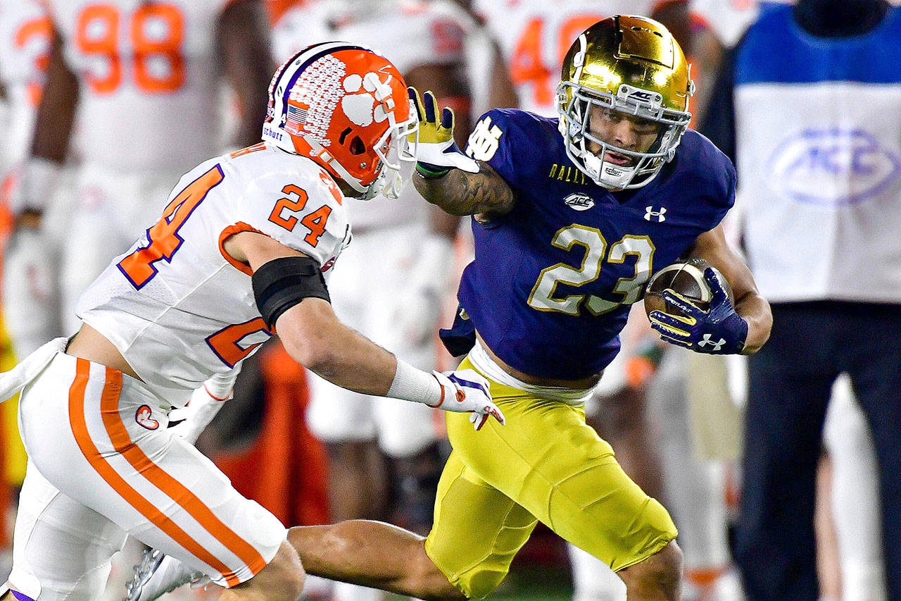 Notre Dame running back Kyren Williams (23) fends off Clemson Tigers safety Nolan Turner (24) on his way to a touchdown Saturday, Nov. 7, 2020, in South Bend, Ind. (Matt Cashore/Pool Photo via AP)