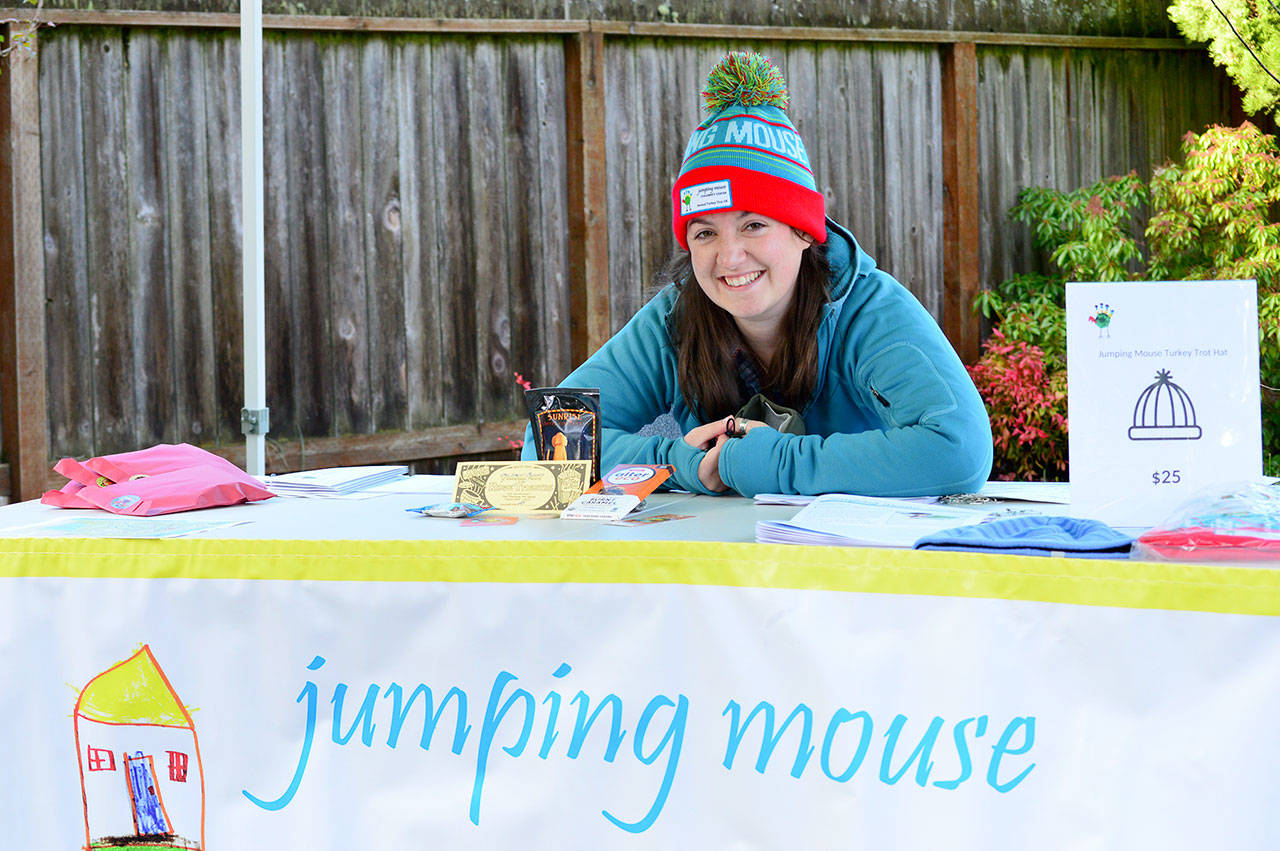 Jumping Mouse Children’s Center race director Whitney Friddle shows off contents of the Turkey Trot virtual fun run goodie bag: coffee, chocolate and a popcorn gift certificate from local businesses. The 5K run/walk and family scavenger hunt will happen all of Thanksgiving week. (Diane Urbani de la Paz/Peninsula Daily News)